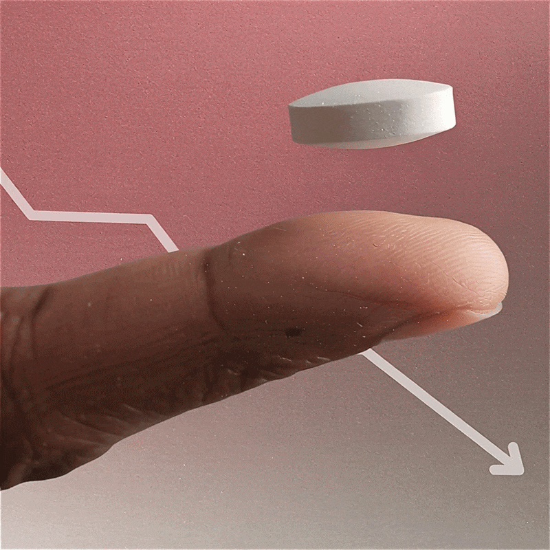 White wegovy pill hovering above an outstretched finger against a pink background with a descending arrow line graph.