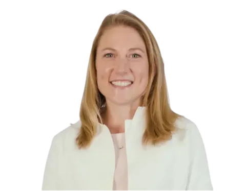 UK-registered clinician smiling in a white coat.