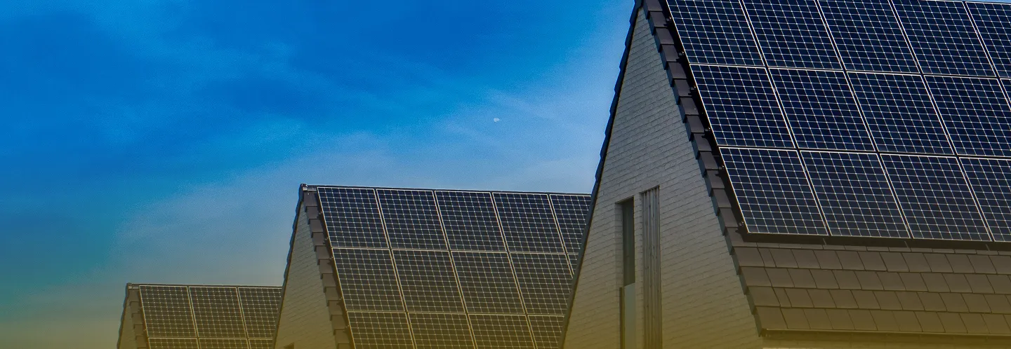 Rooftops with solar panels under a clear blue sky during daylight.