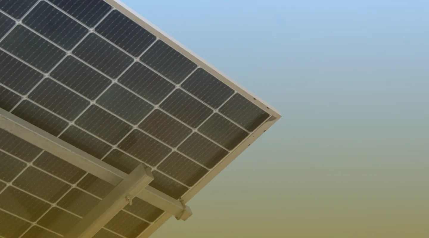 Close-up view of a solar panel mounted on a metal frame against a clear sky.