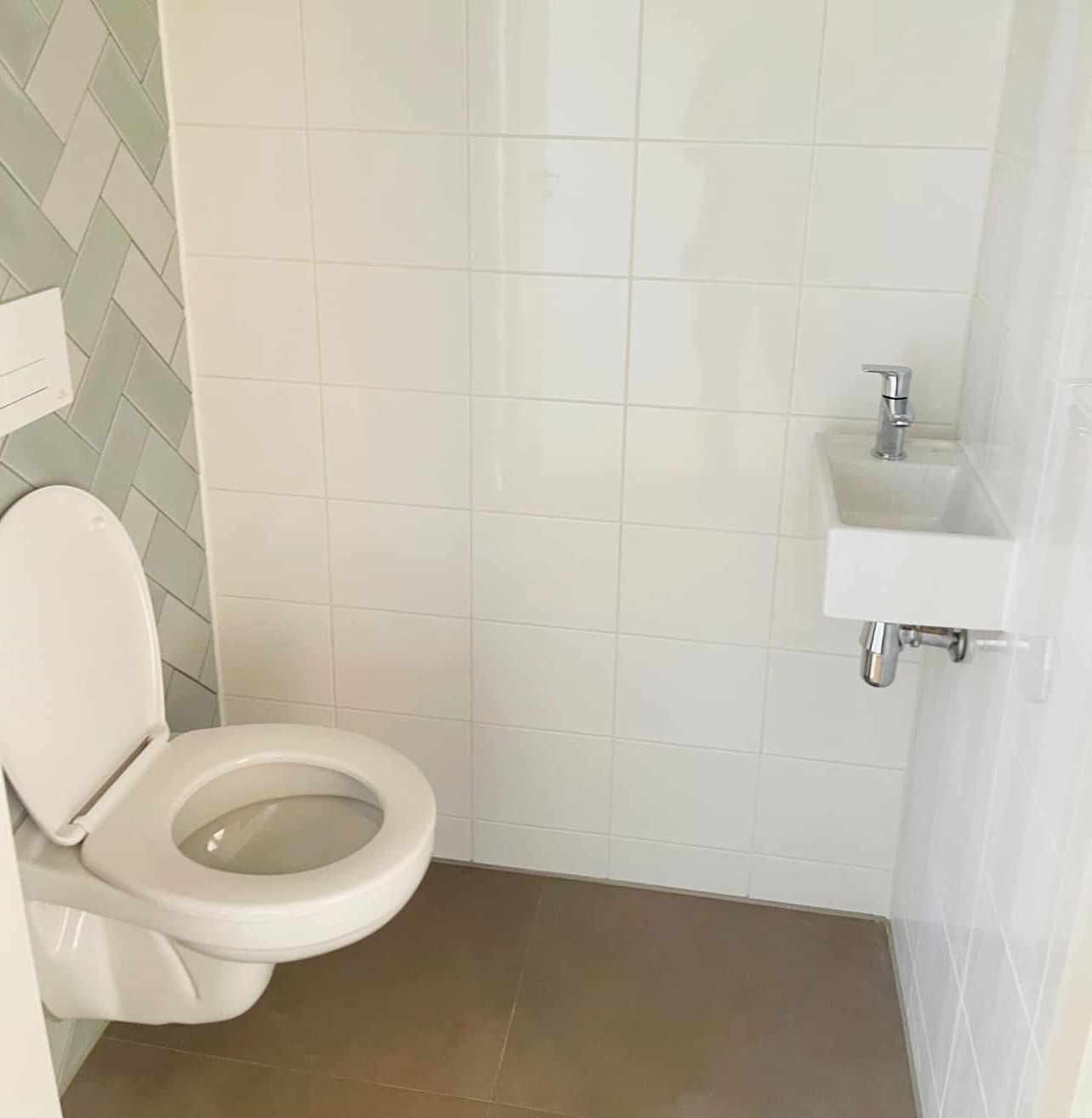 Moderne wc met groende decortegels