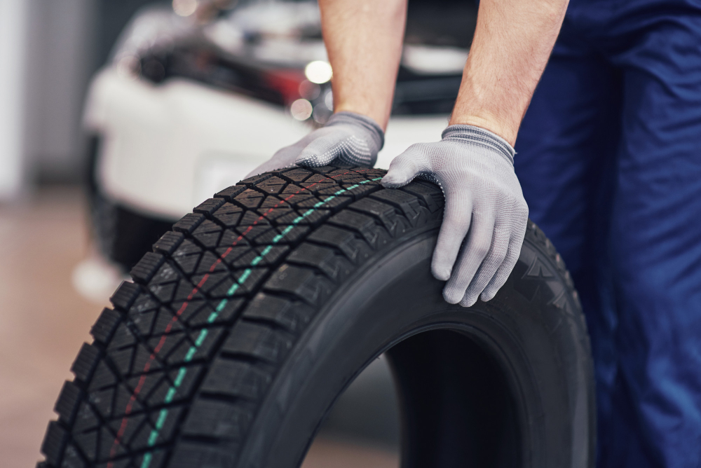 Mechanic rolling a new tire in a garage
