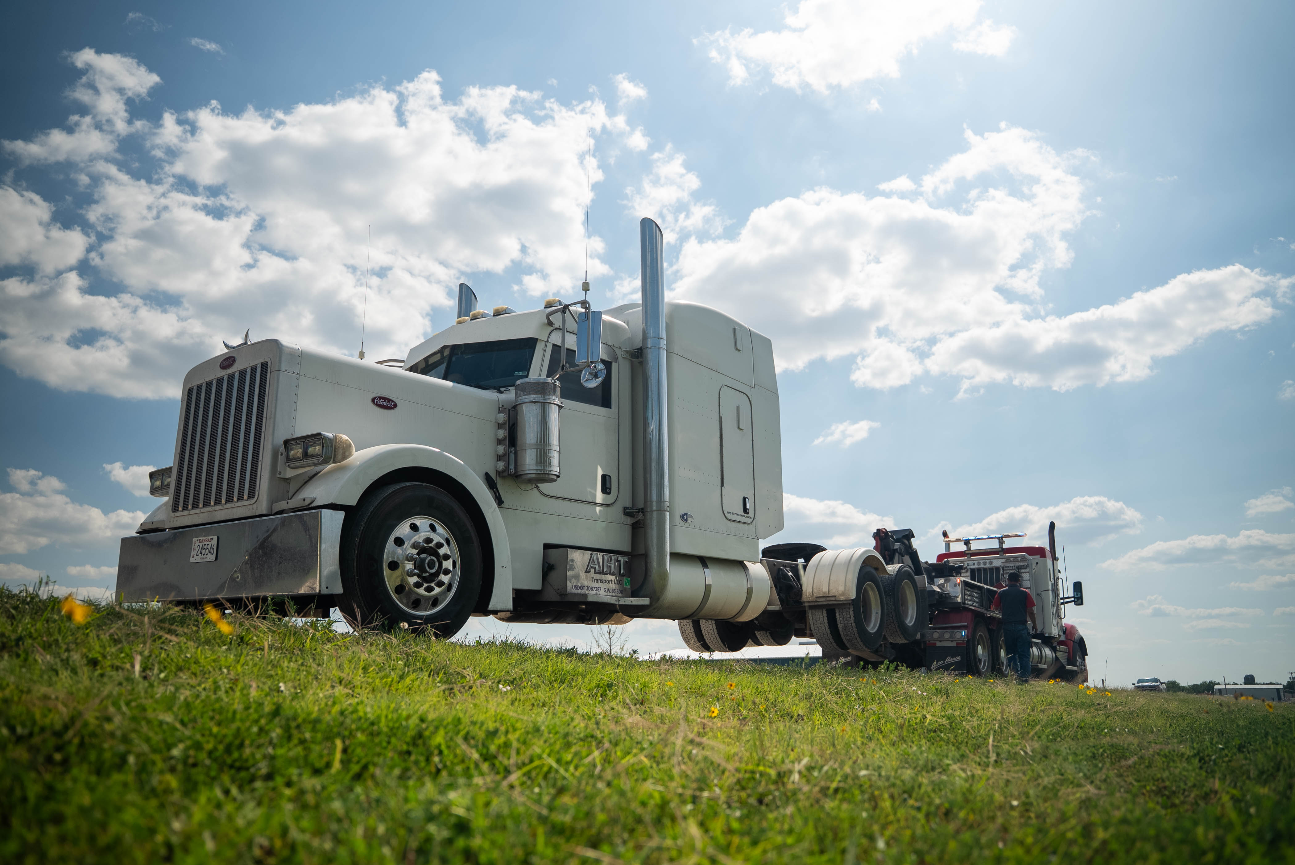 Auto House heavy wrecker towing a white Peterbilt semi tractor