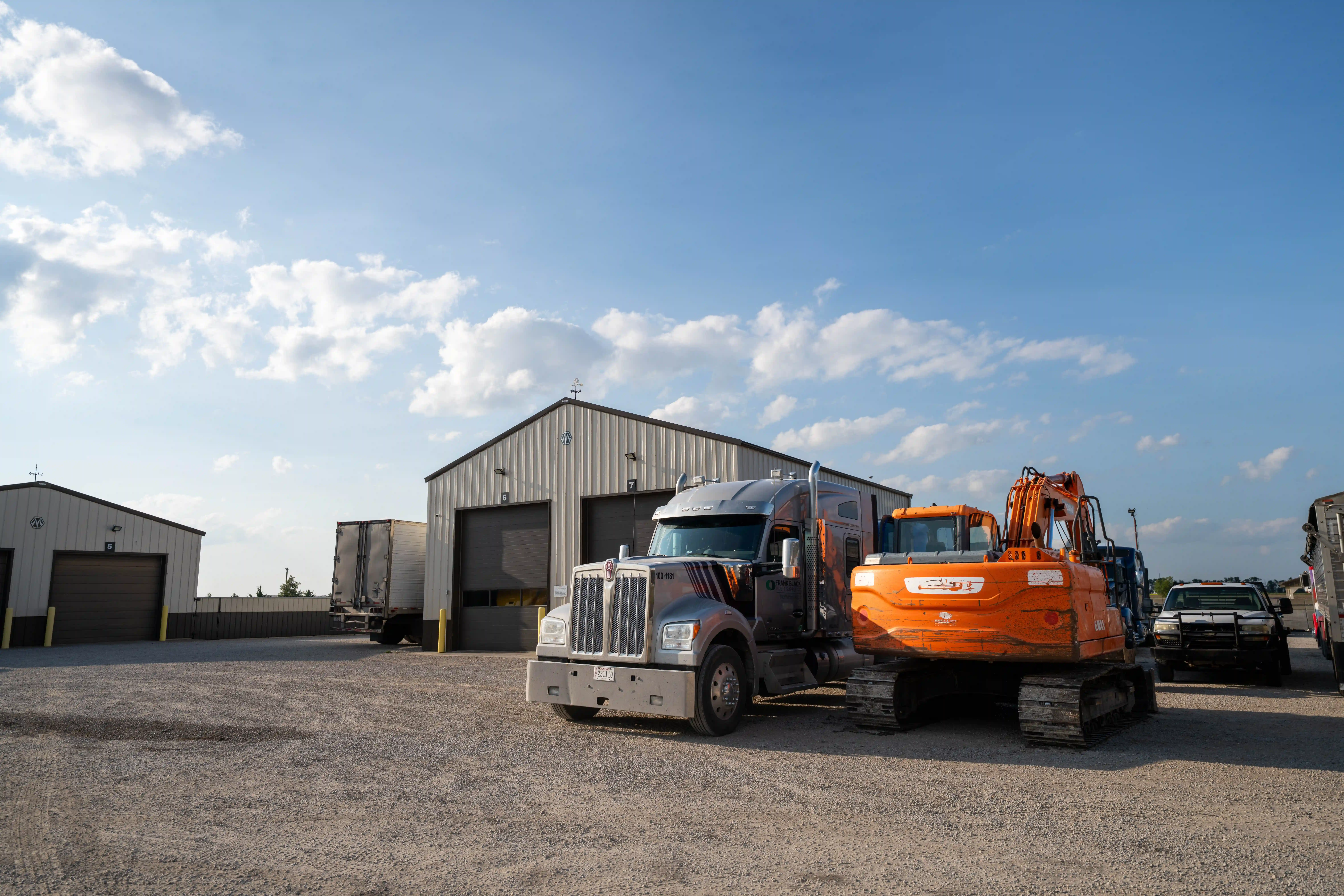 Kenworth tractor and an excavator parked outside the Auto House shop
