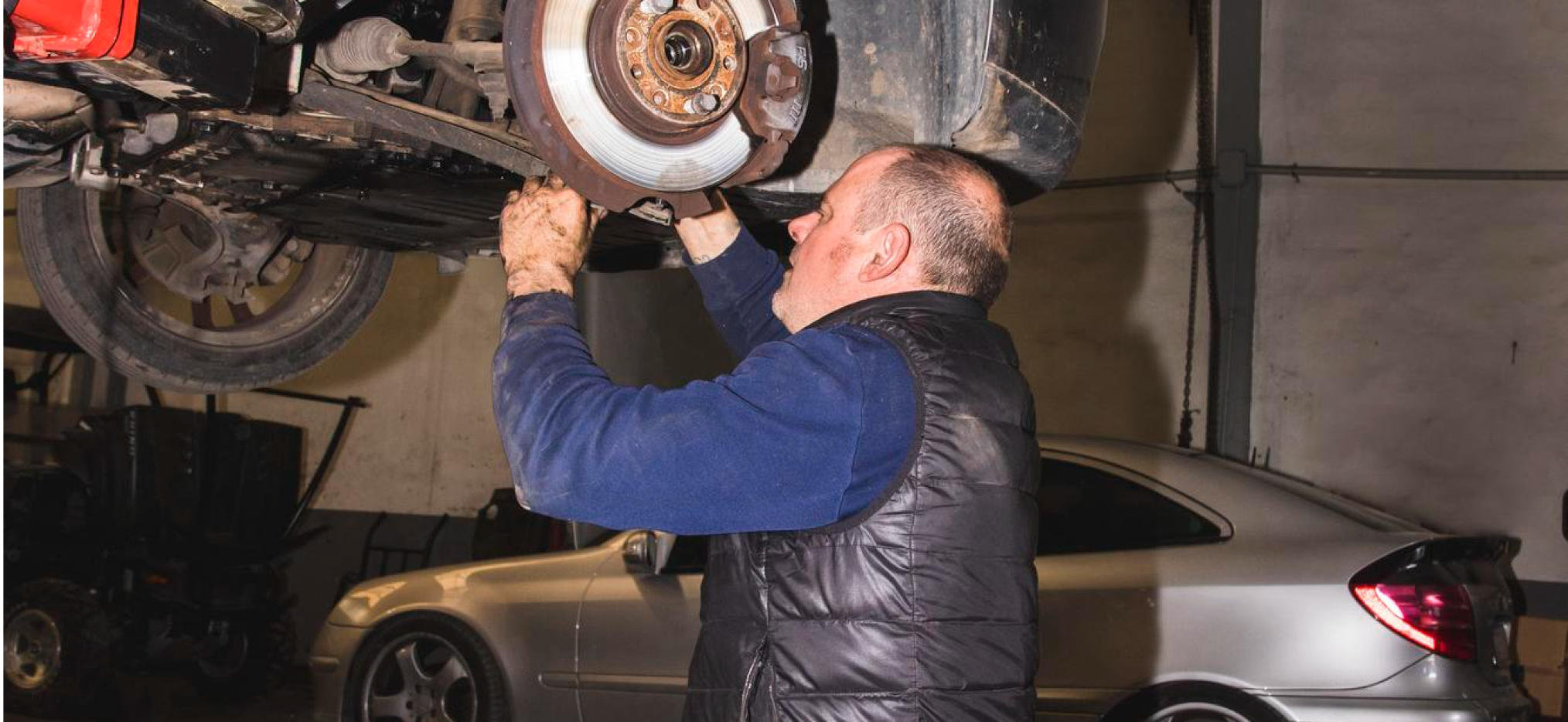 Mechanic working on a car brake rotor in a garage
