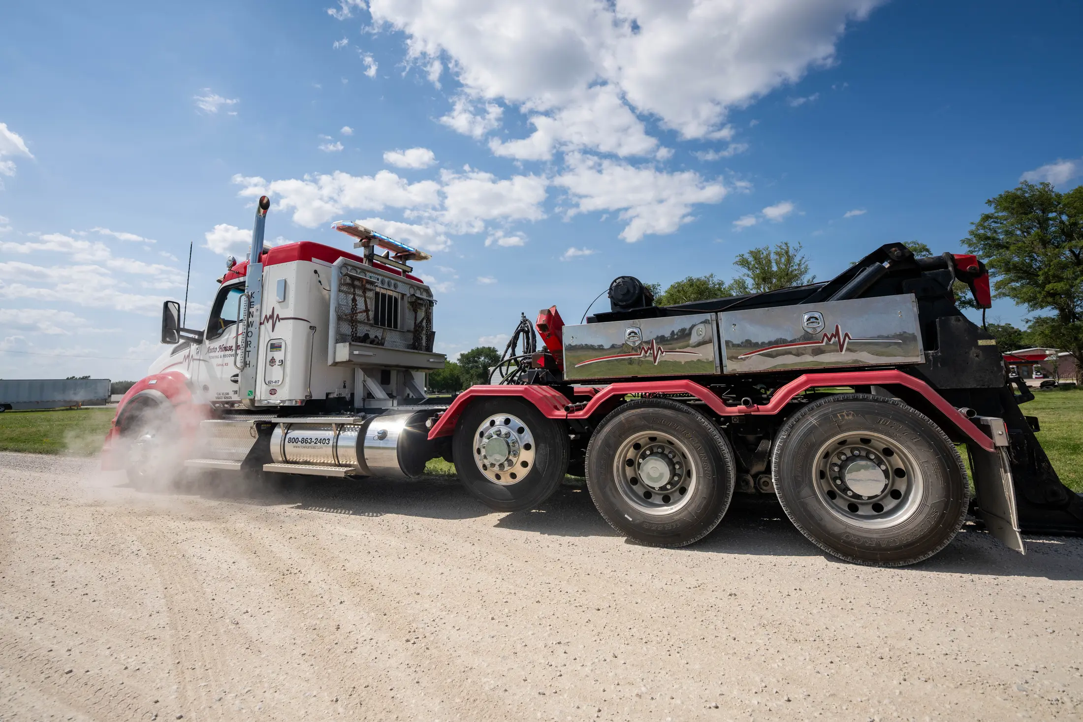 Auto House heavy wrecker rolling down a gravel road