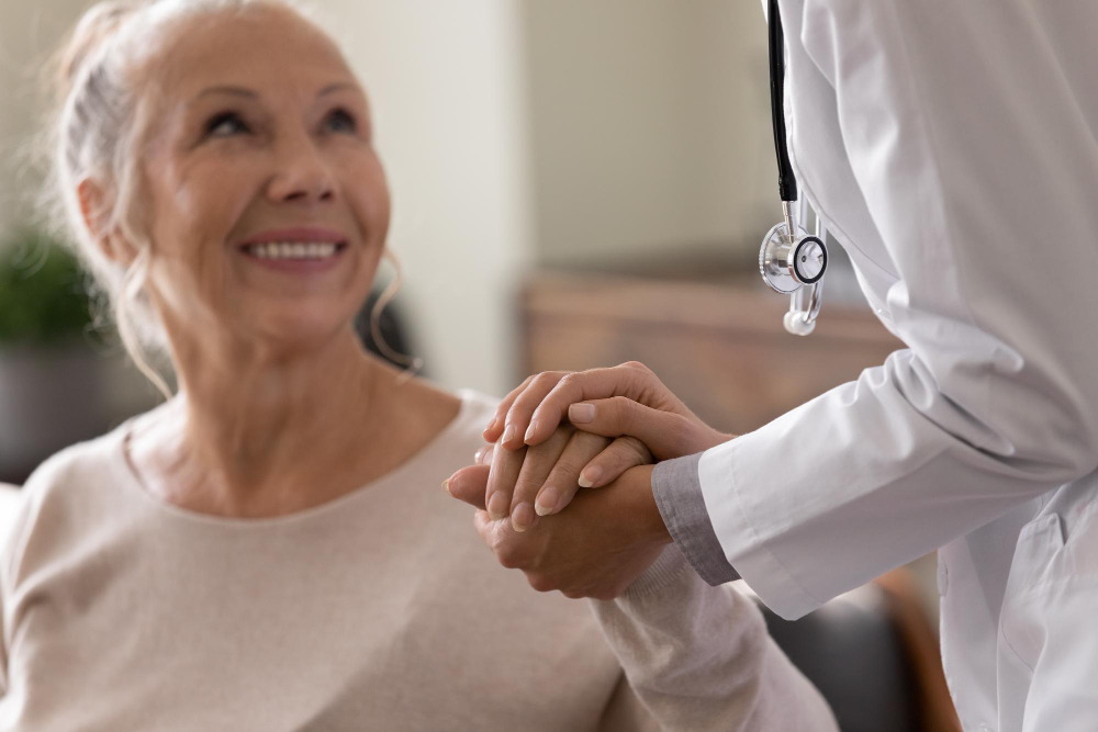 Healthcare professional holding an older woman's hand during a consultation