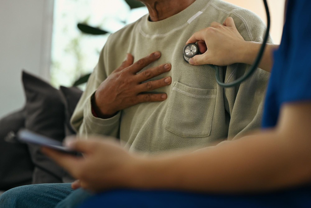 Healthcare professional listening to an older man's chest with a stethoscope