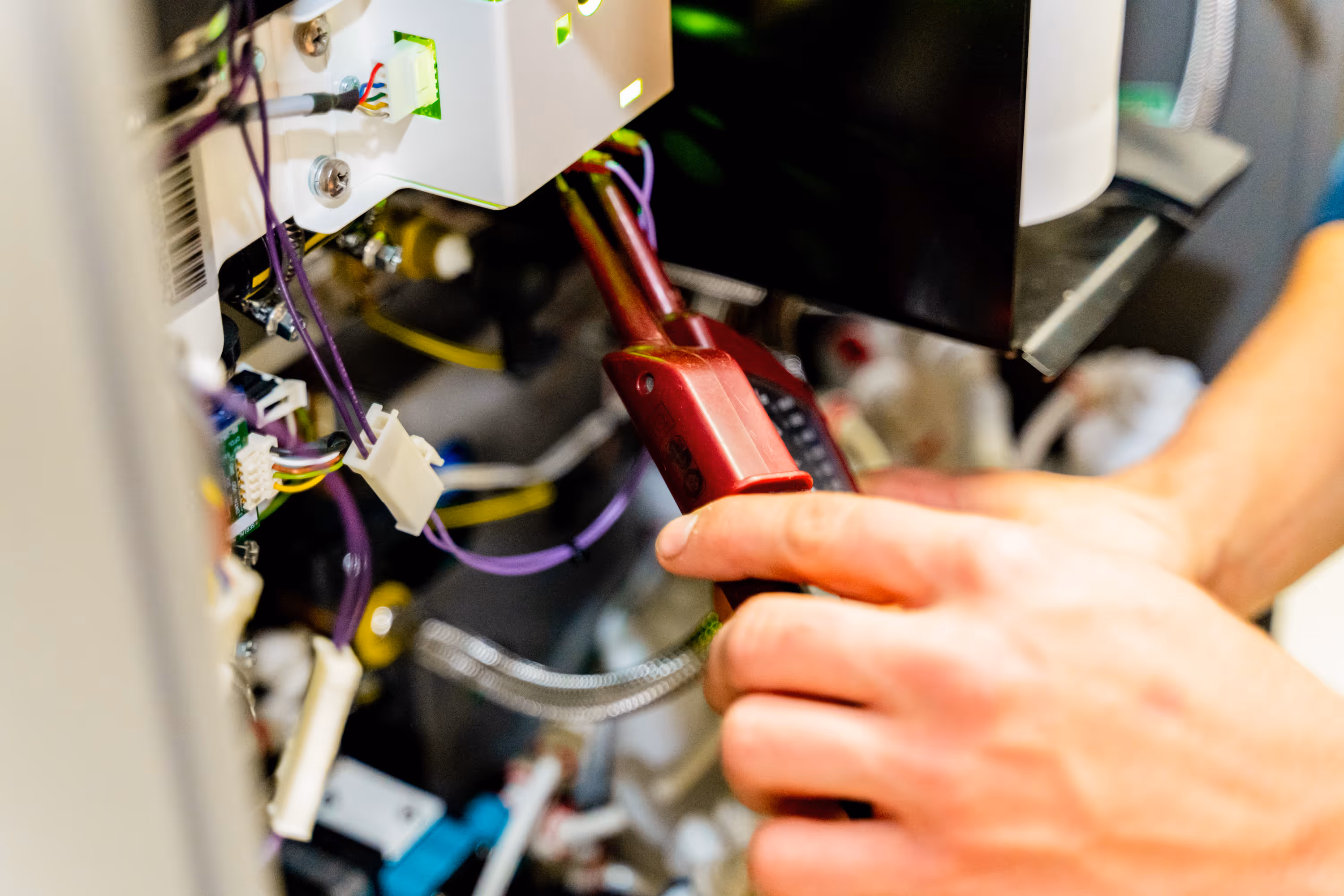 Nahaufnahme: Zwei Hände hantieren mit Elektrokabeln