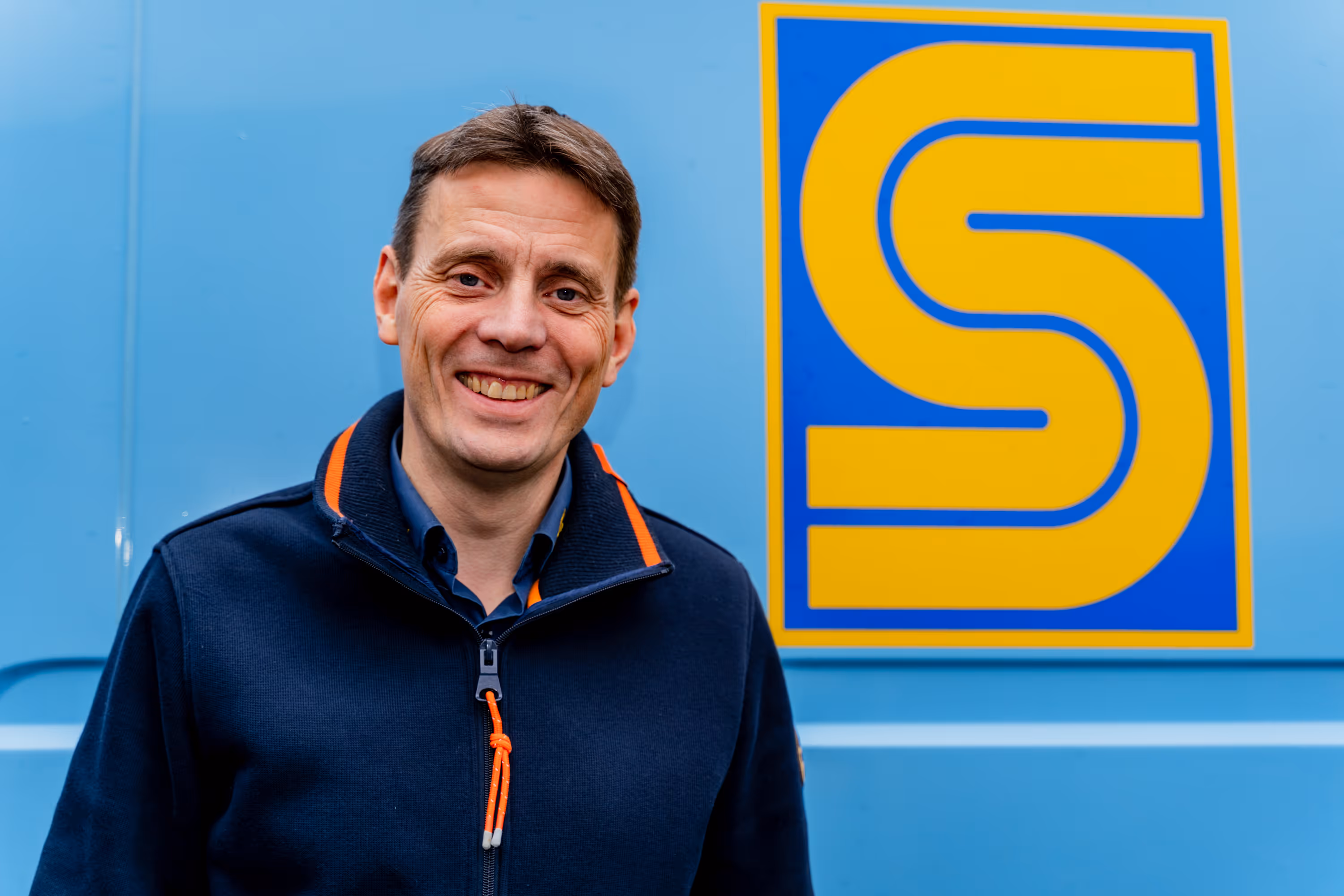 Ehemaliger Geschäftsführer Joachim Scheel vor Firmenwagen