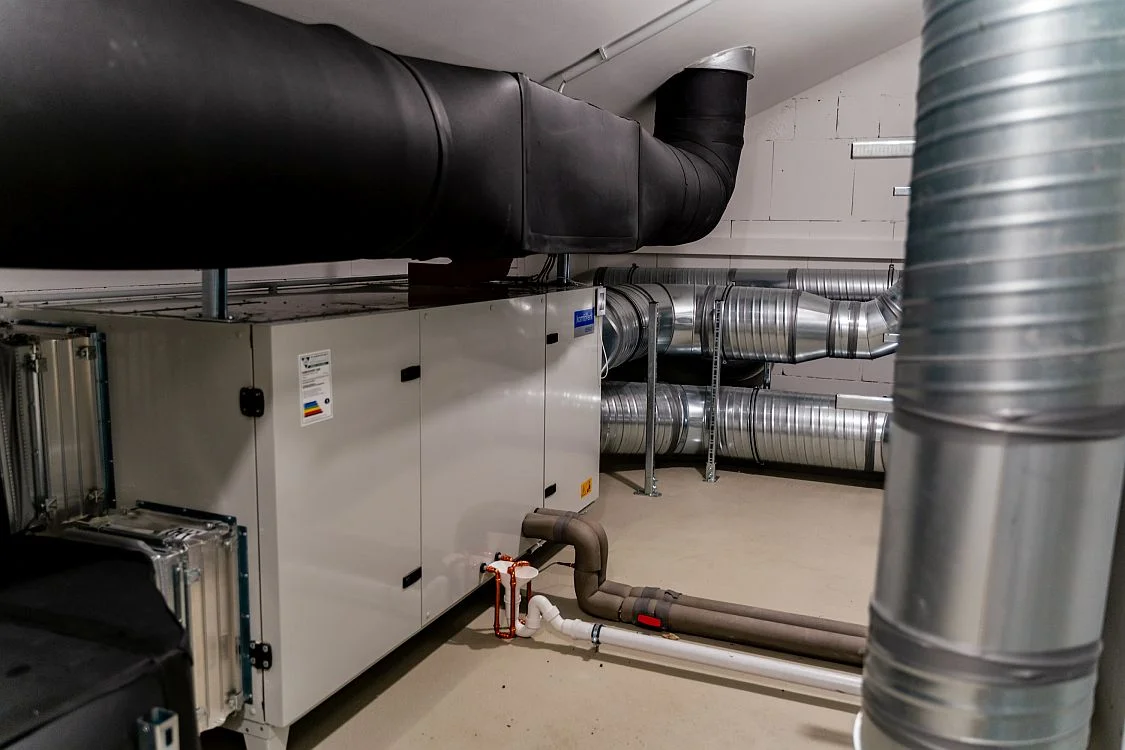 Gewerbliche Wärmepumpenanlage mit großen Lüftungsrohren im Keller