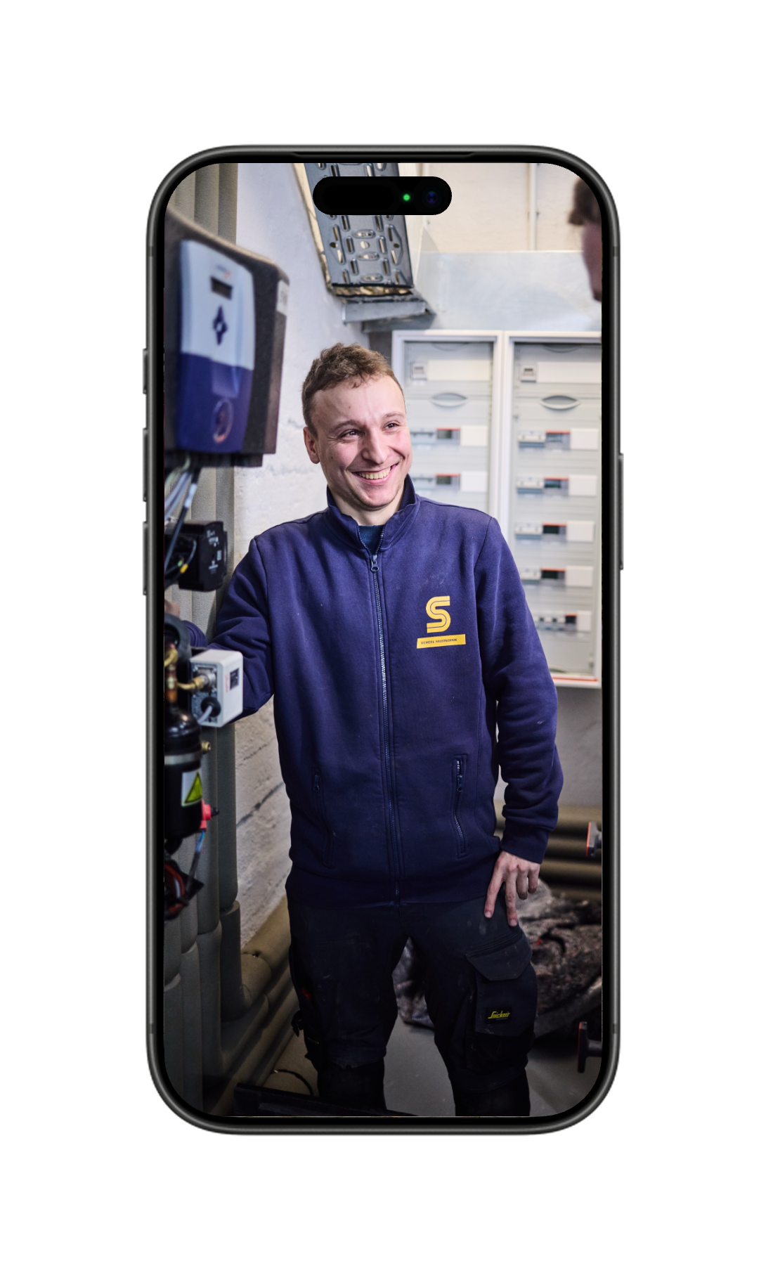 Smartphone mit Foto eines lächelnden Scheel Mitarbeiters in blauer Arbeitsjacke
