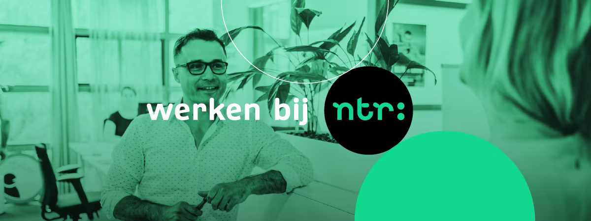 Een lachende man met bril zit achter een bureau in een modern kantoor met planten op de achtergrond, met het logo "werken bij ntr".