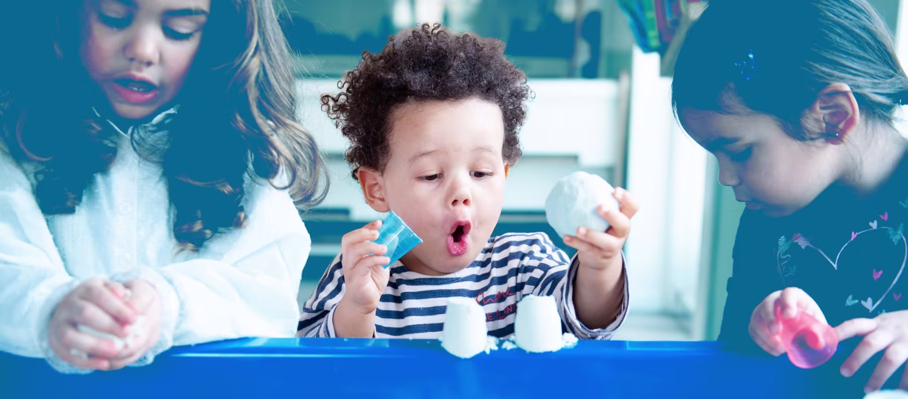 Kinderen en begeleiders doen samen een experiment met reageerbuisjes in een kinderdagverblijf.