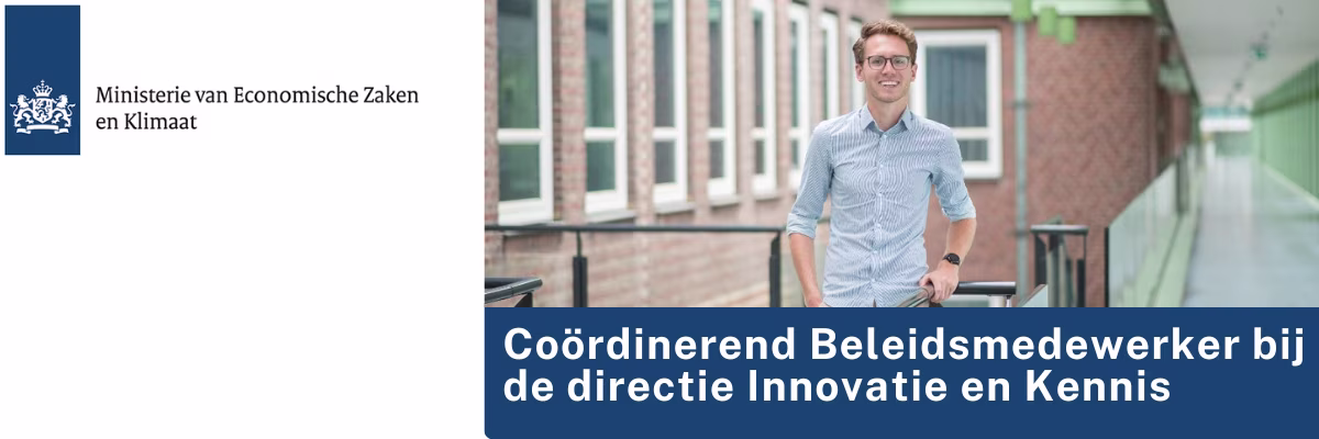 Een man in blauw overhemd staat glimlachend op een brug, met op de achtergrond karakteristieke Nederlandse architectuur.