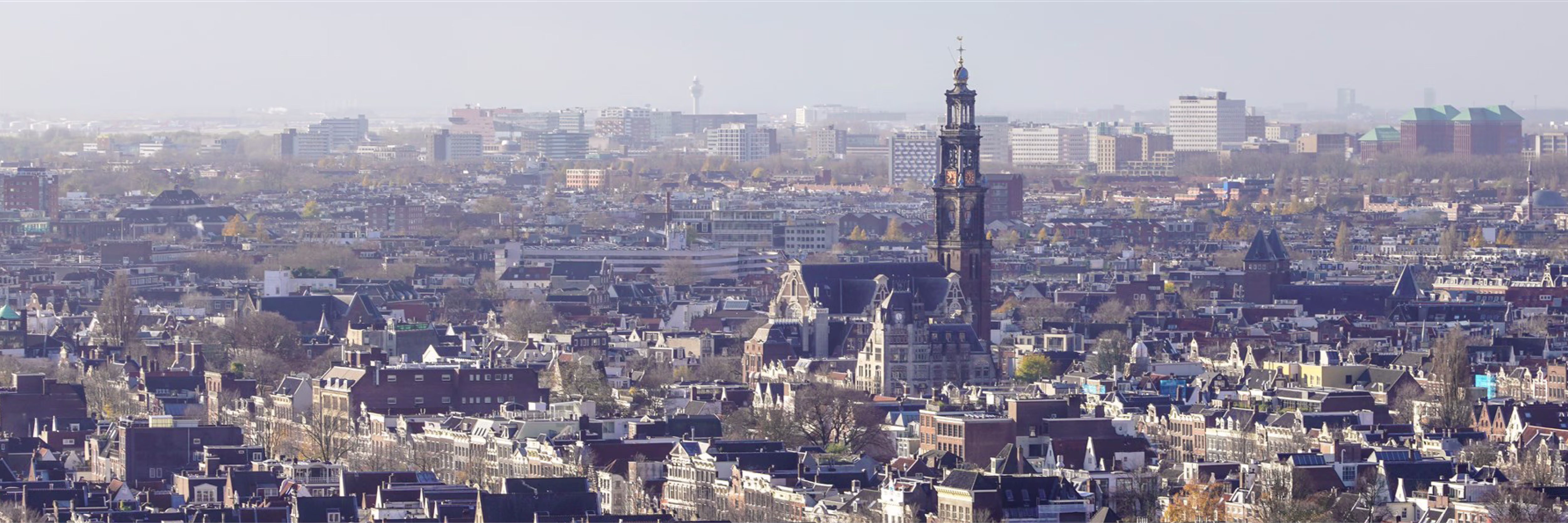 Panoramisch uitzicht over Amsterdam met de Westerkerk en moderne kantoorgebouwen op de achtergrond.