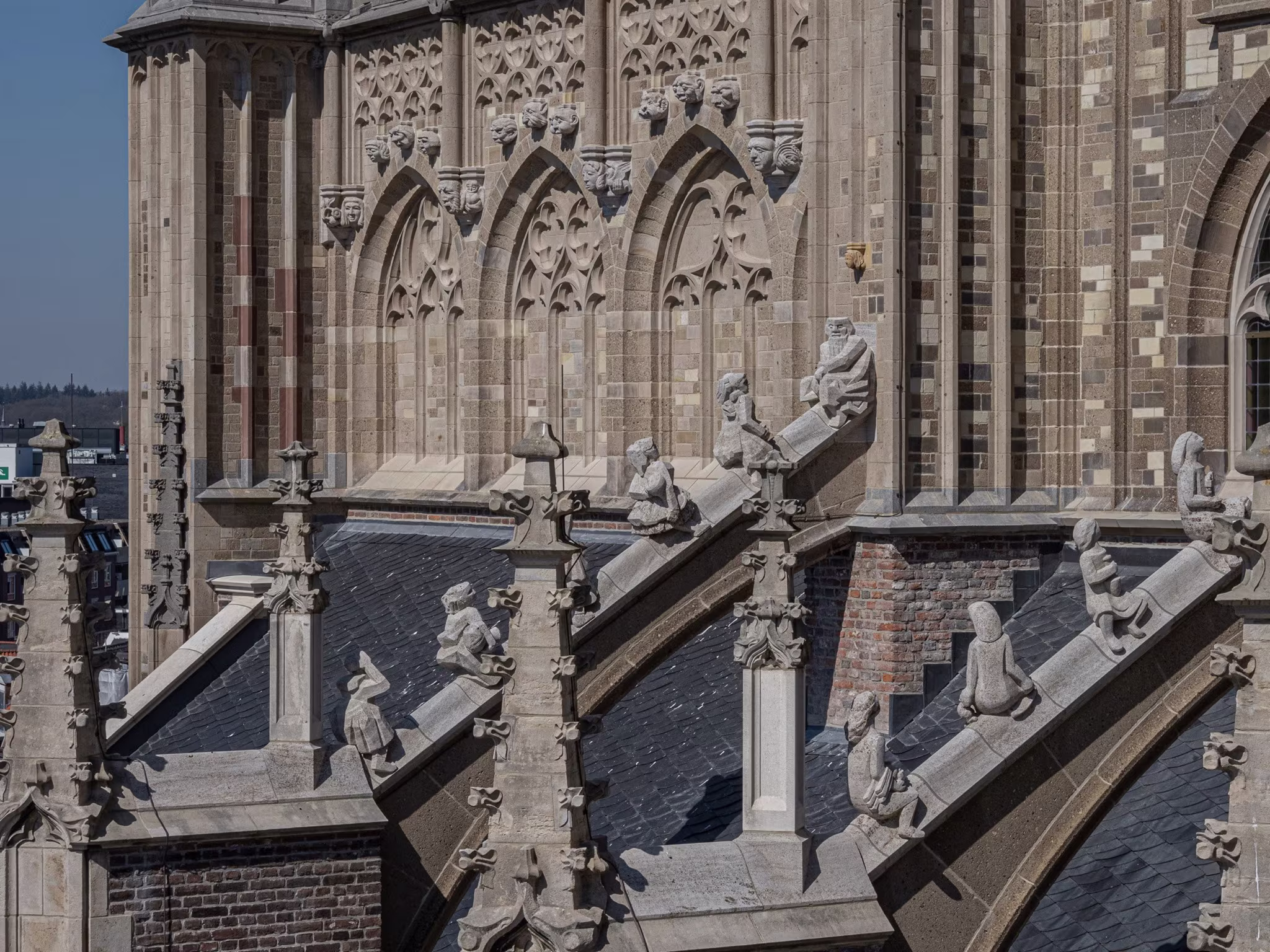 Gotische architectuur van de Eusebiuskerk in Arnhem met gedetailleerde steenbewerking, bogen en sculpturen op het dak.