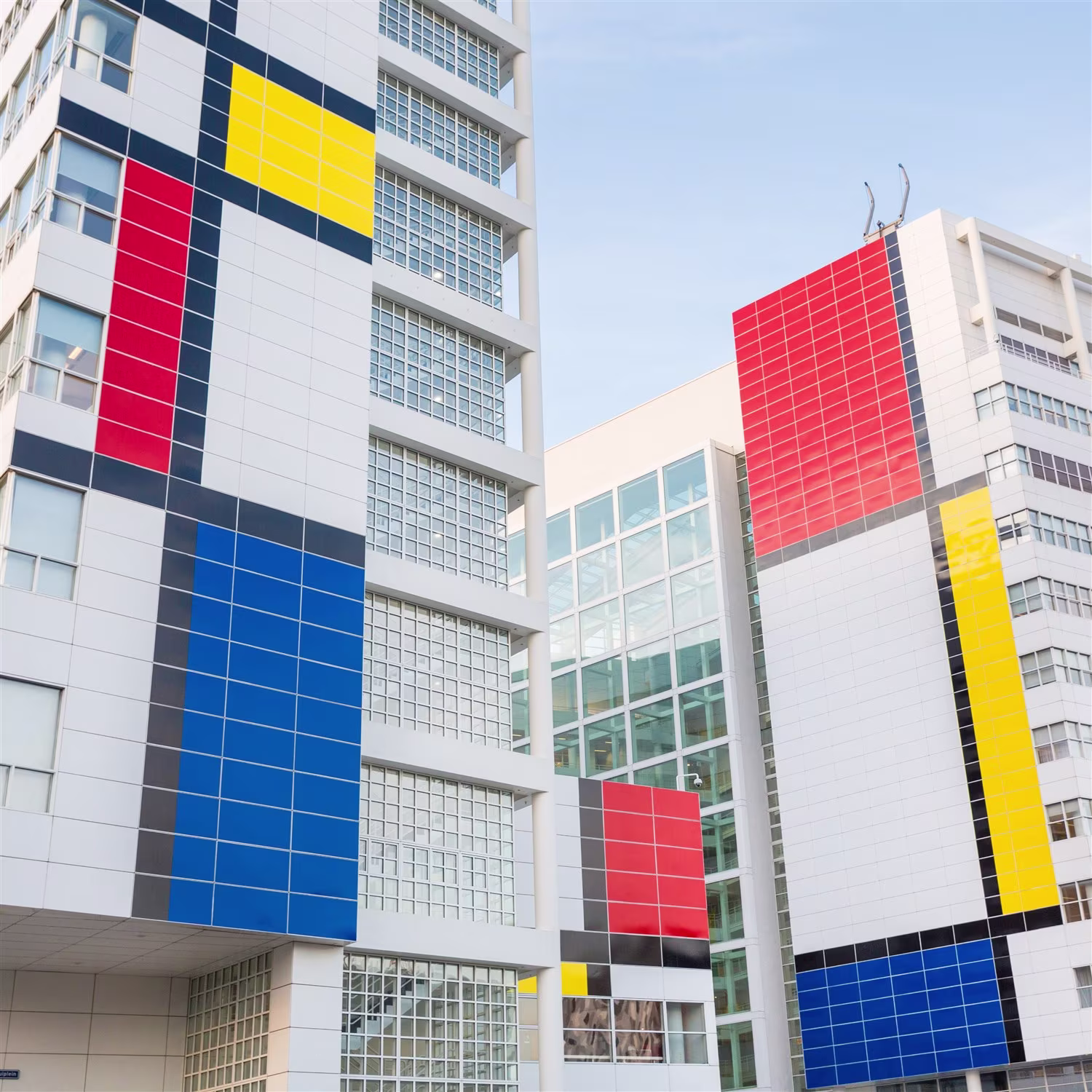 Moderne gebouwen met kleurrijke gevel-elementen in rood, geel en blauw, kenmerkend voor hedendaagse architectuur.