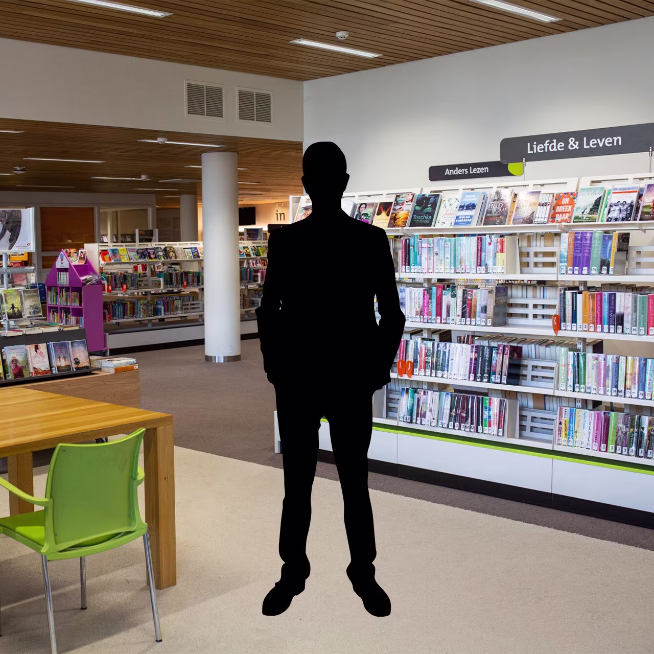 Een zwart silhouet van een persoon staat in een moderne bibliotheek tussen boekenkasten en leestafels.