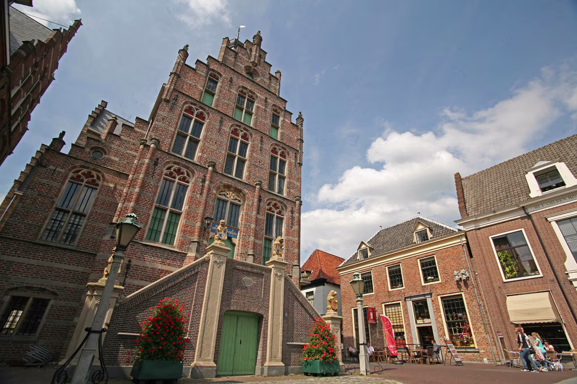 Historisch stadhuis van Culemborg met karakteristieke trapgevel en bakstenen architectuur op een zonnige dag.