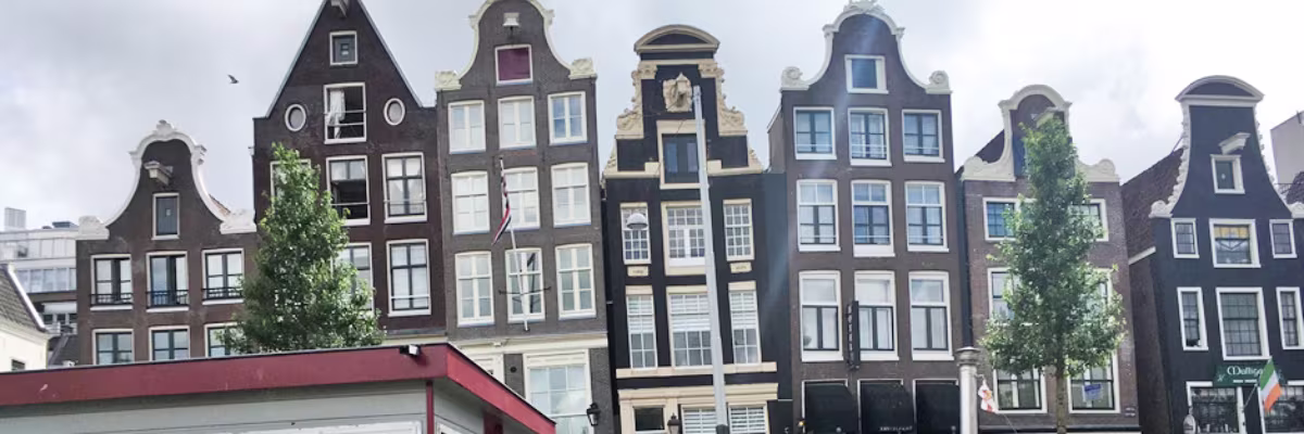 Typische Amsterdamse grachtenpanden met smalle gevels en karakteristieke trapgevels langs een gracht.