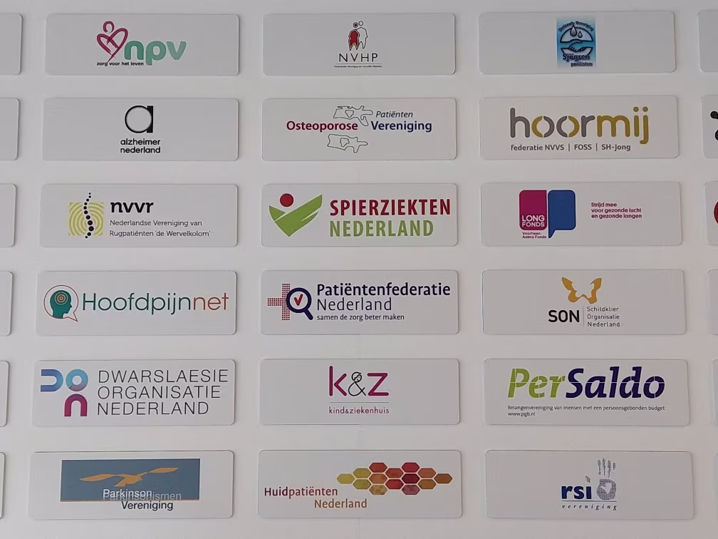 Een grid van witte kaartjes met logo's van verschillende Nederlandse patiëntenorganisaties en zorgverenigingen op een grijze achtergrond.