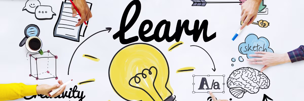 Creatieve werkplek met handen die tekenen rond het woord "learn" en een gele gloeilamp, symboliserend leren en innovatie.