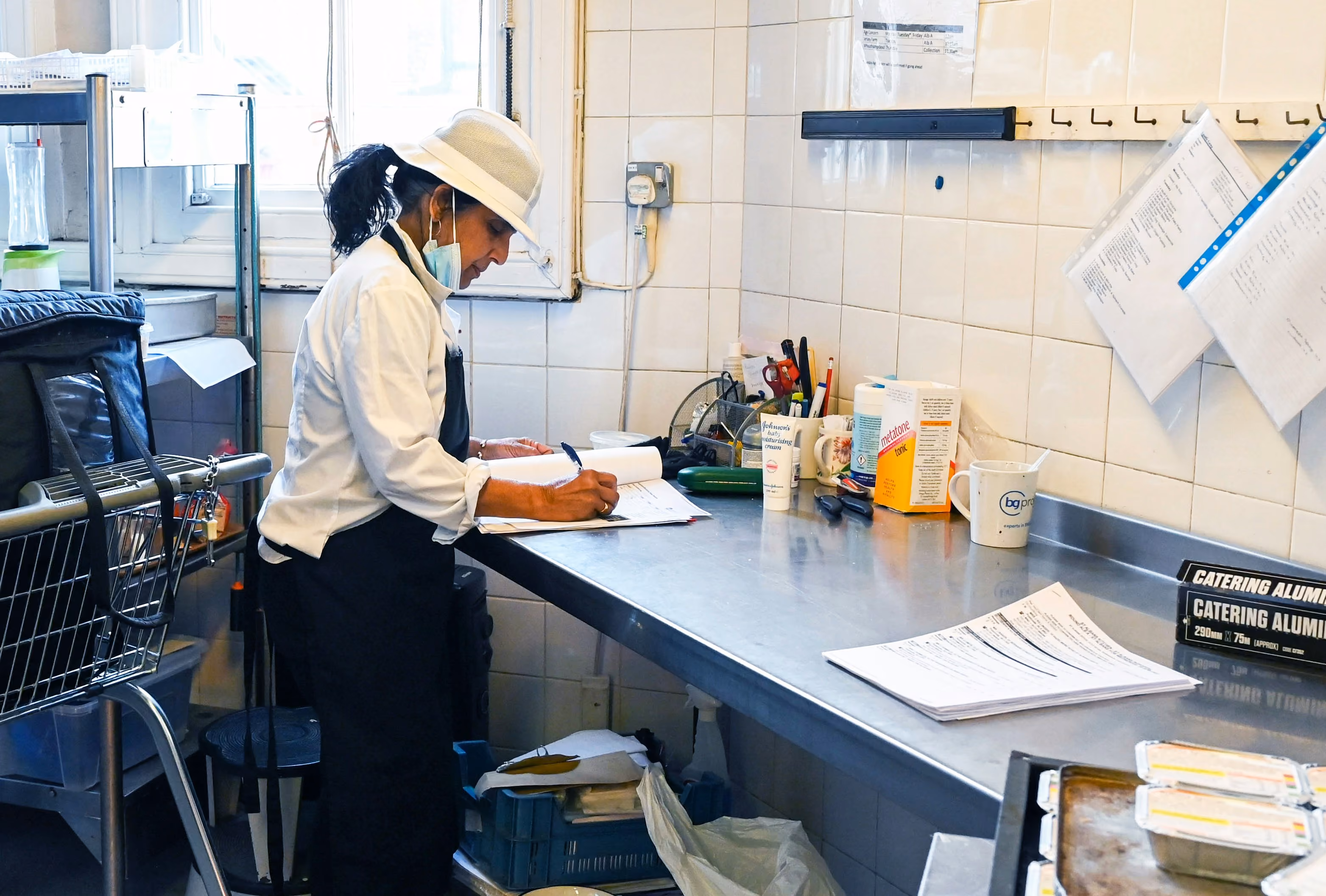 Kitchen team member completing morning food safety opening checks on a mobile device