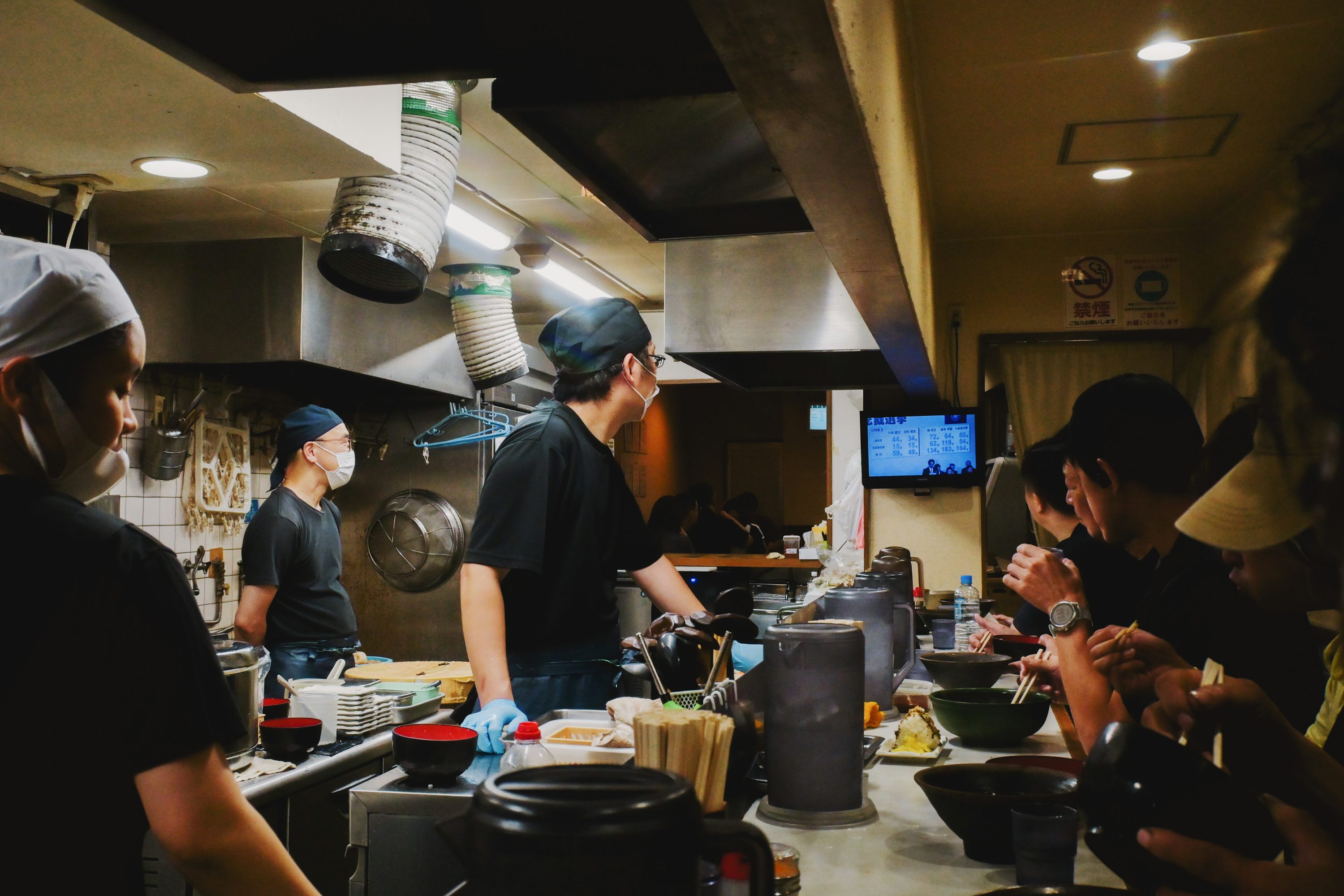 Multiple kitchen staff working together during a busy service in a commercial restaurant kitchen