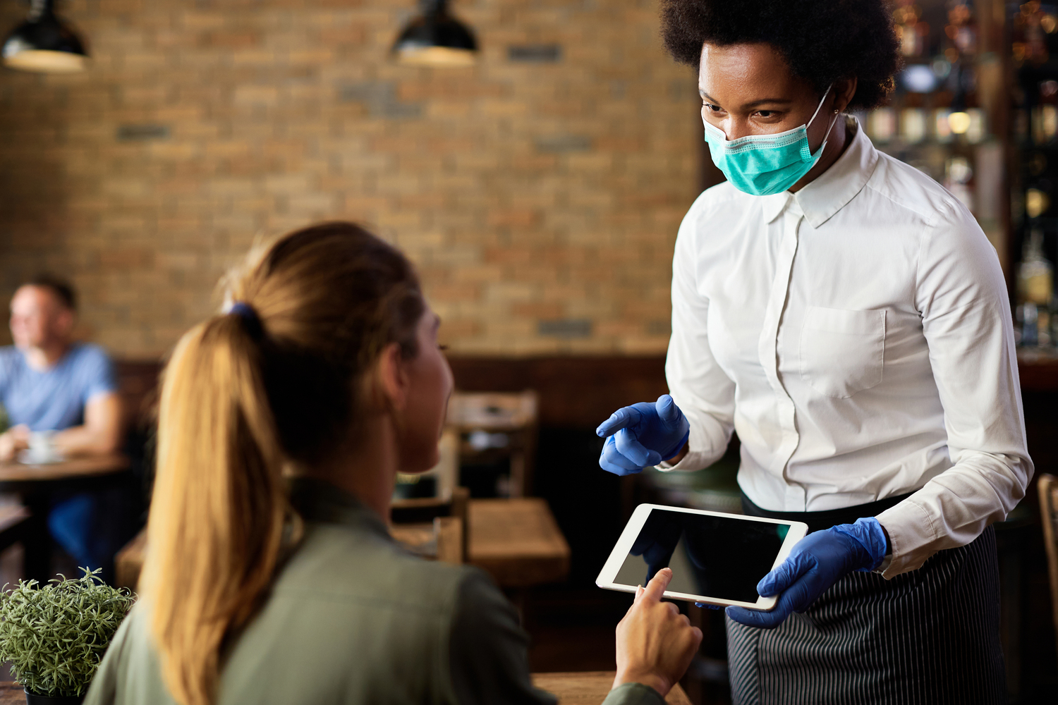 Person holding a tablet with a pen reviewing kitchen temperature control data displayed on a smart oven dashboard