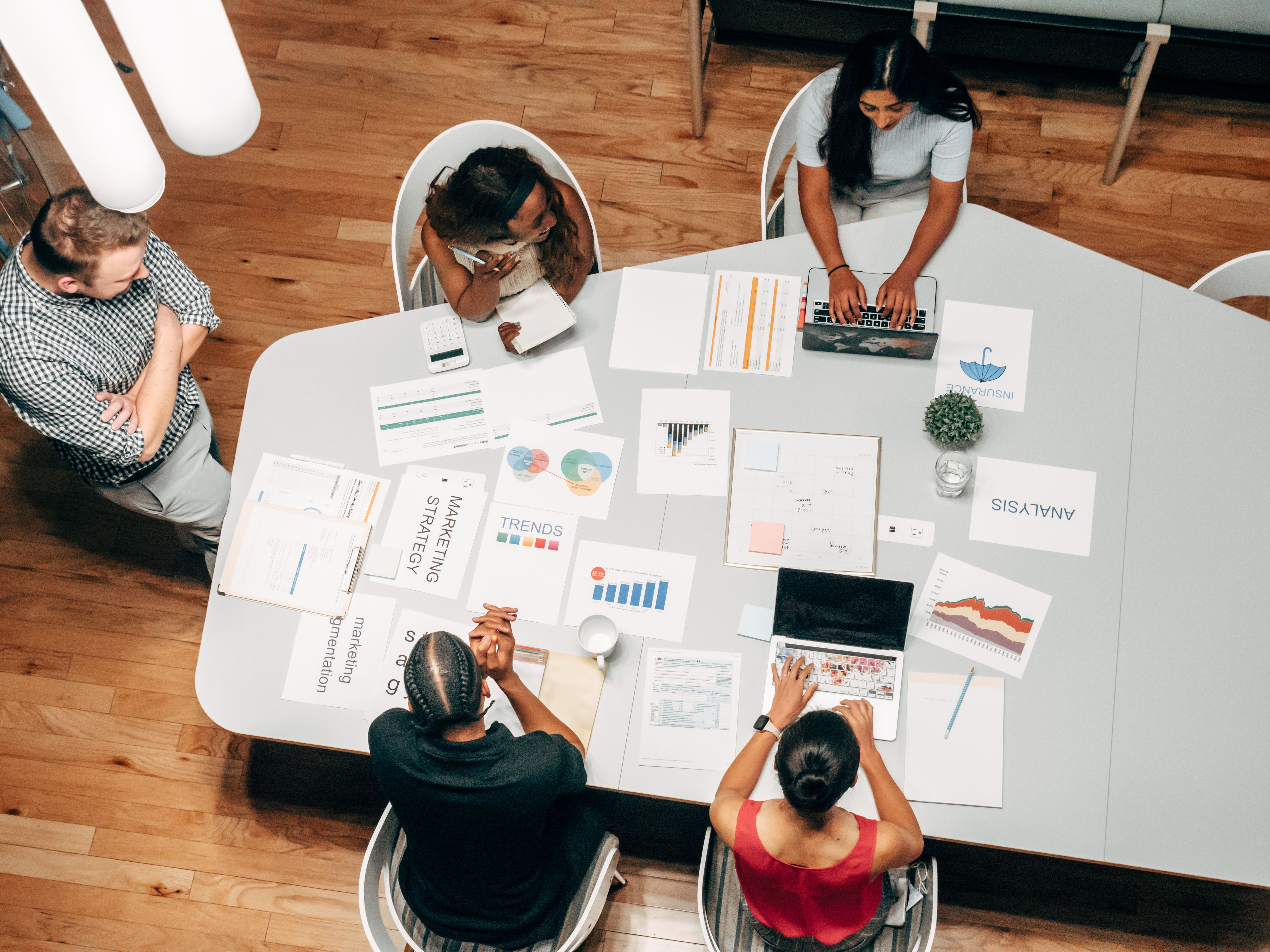 Aerial view of a corporate team collaborating on audit documents and analytics.