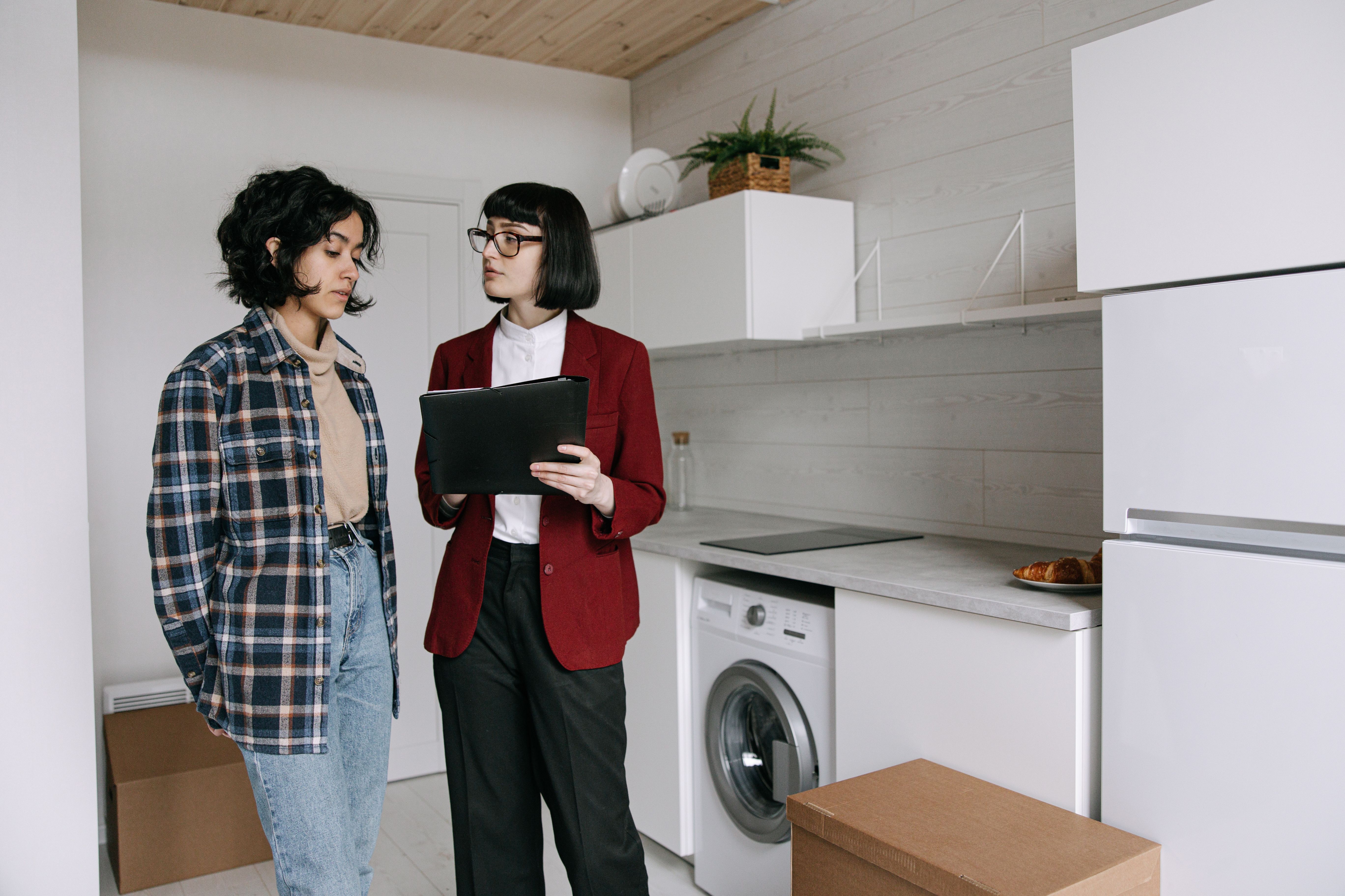 Auditor holding a clipboard while conducting a kitchen evaluation.