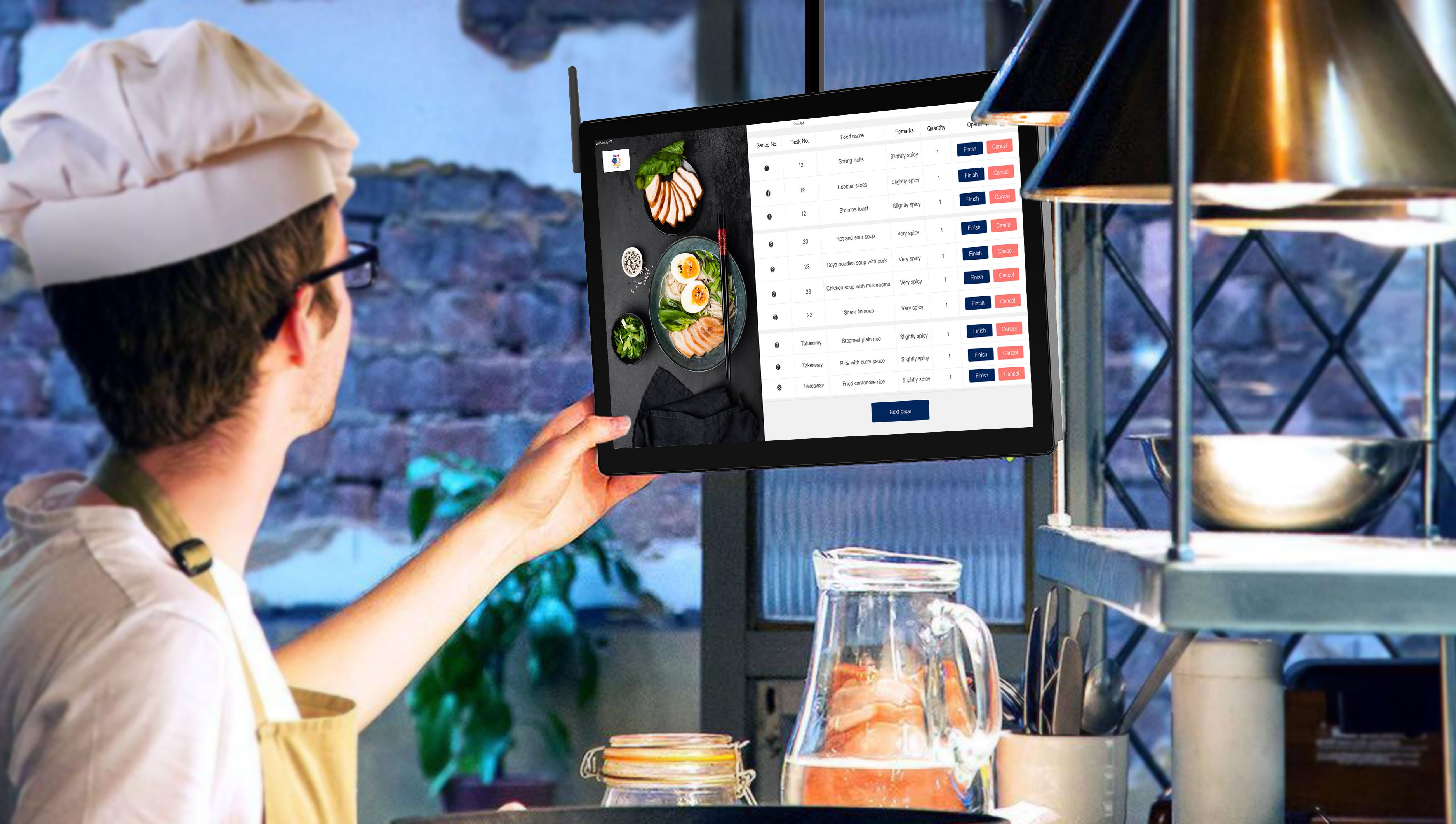 Chef looking at a digital ordering display screen attached to a counter in a restaurant kitchen.