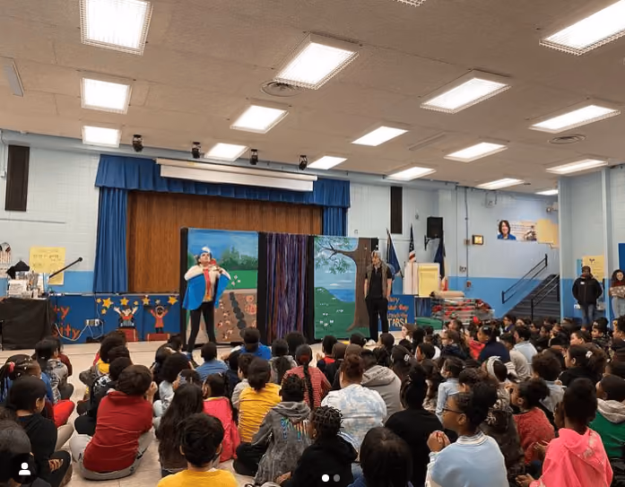 Students watching a live theatrical performance in the school auditorium