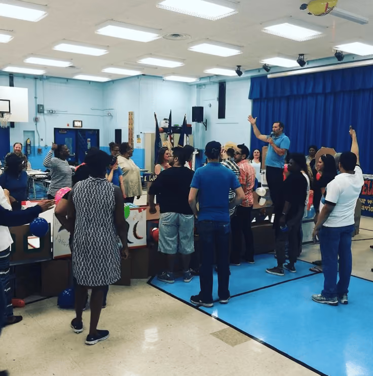 Adults participating in a group activity in a school gymnasium