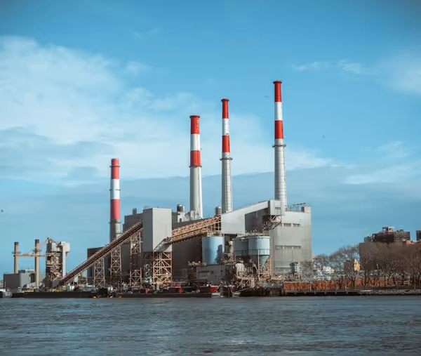 gray and red factory building under a calm blue sky