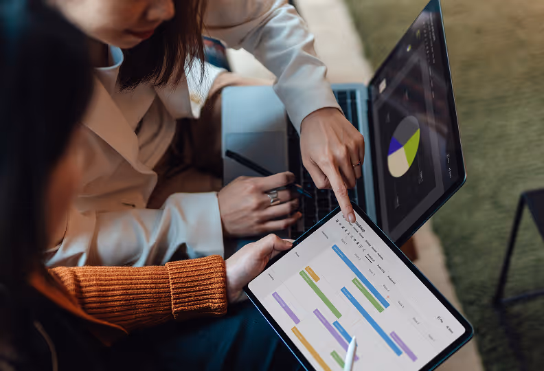people looking at a gantt chart on an ipad