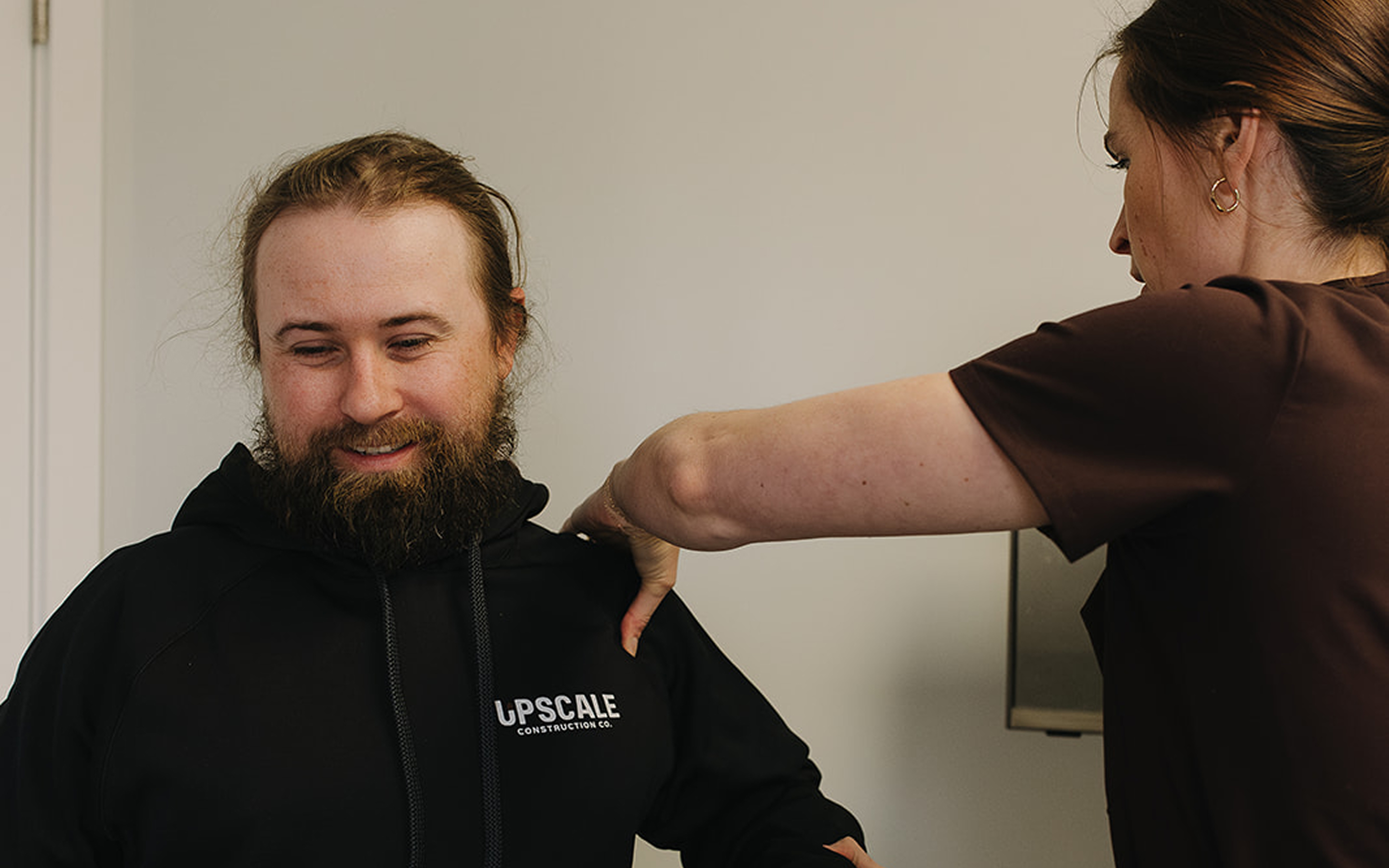 A man with a beard and a black hoodie.