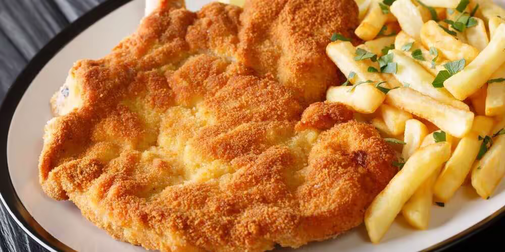 Milanesa casera jugosa y crocante con papas fritas