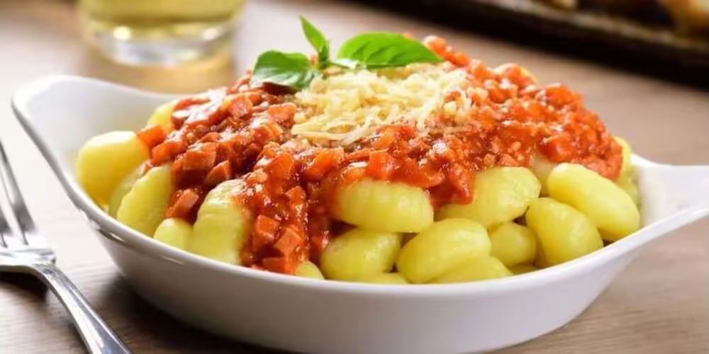Ñoquis de papa caseros con salsa de tomate y queso rallado