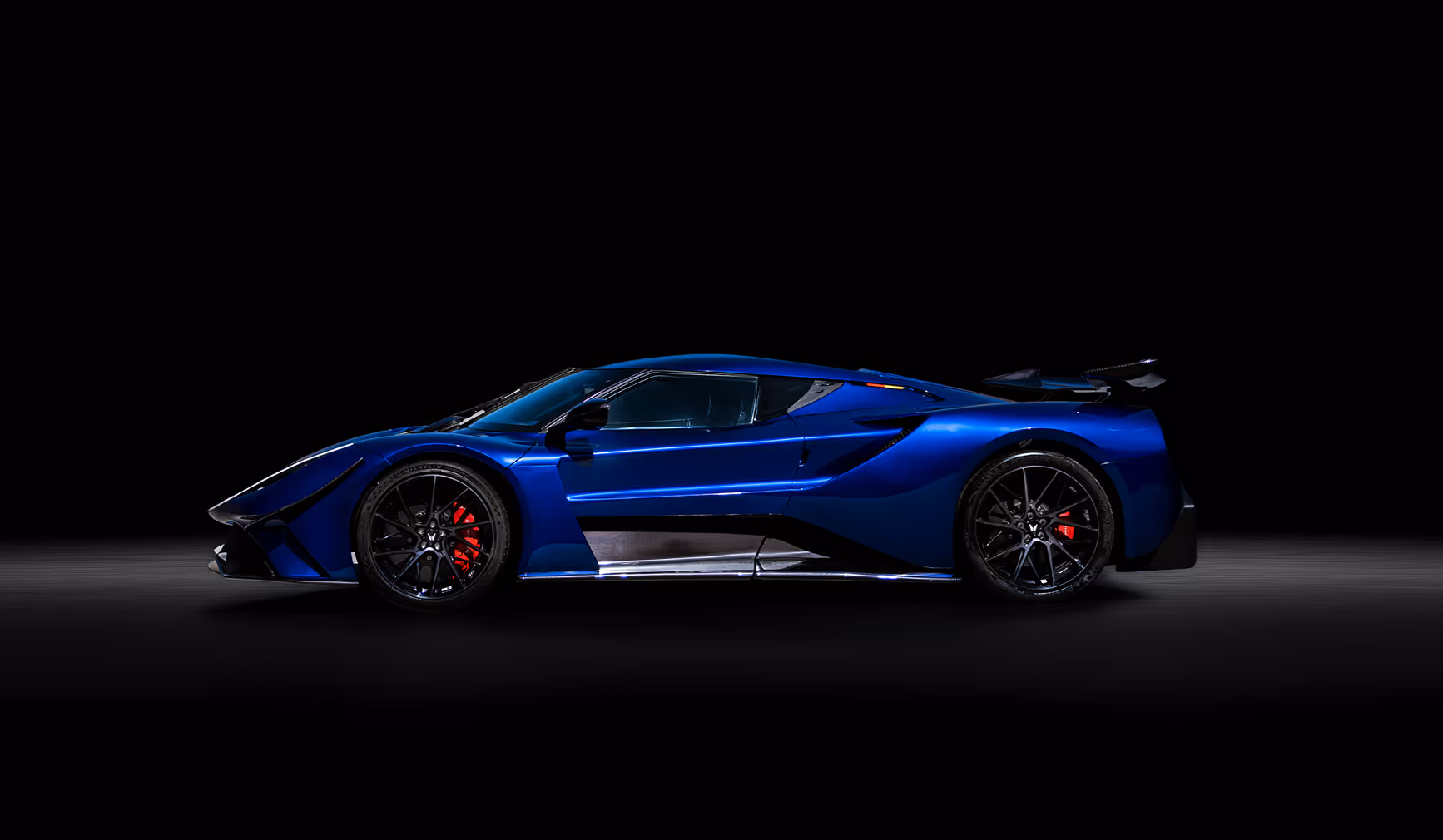 Blue sports car with butterfly doors open, black rims, and red brake calipers on a dark reflective surface.