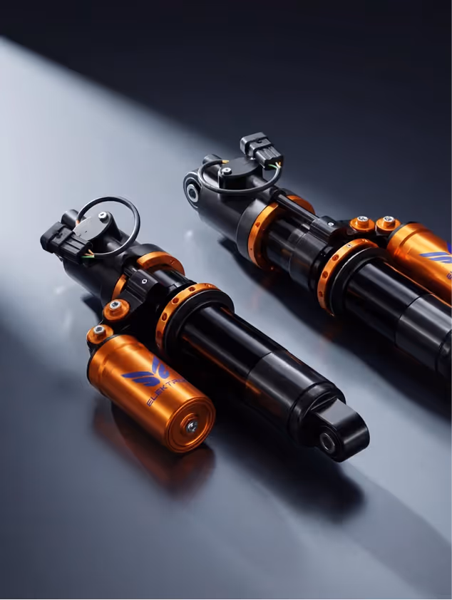 Close-up of a metallic electric motor rotor with copper coils and gear teeth against a black background.