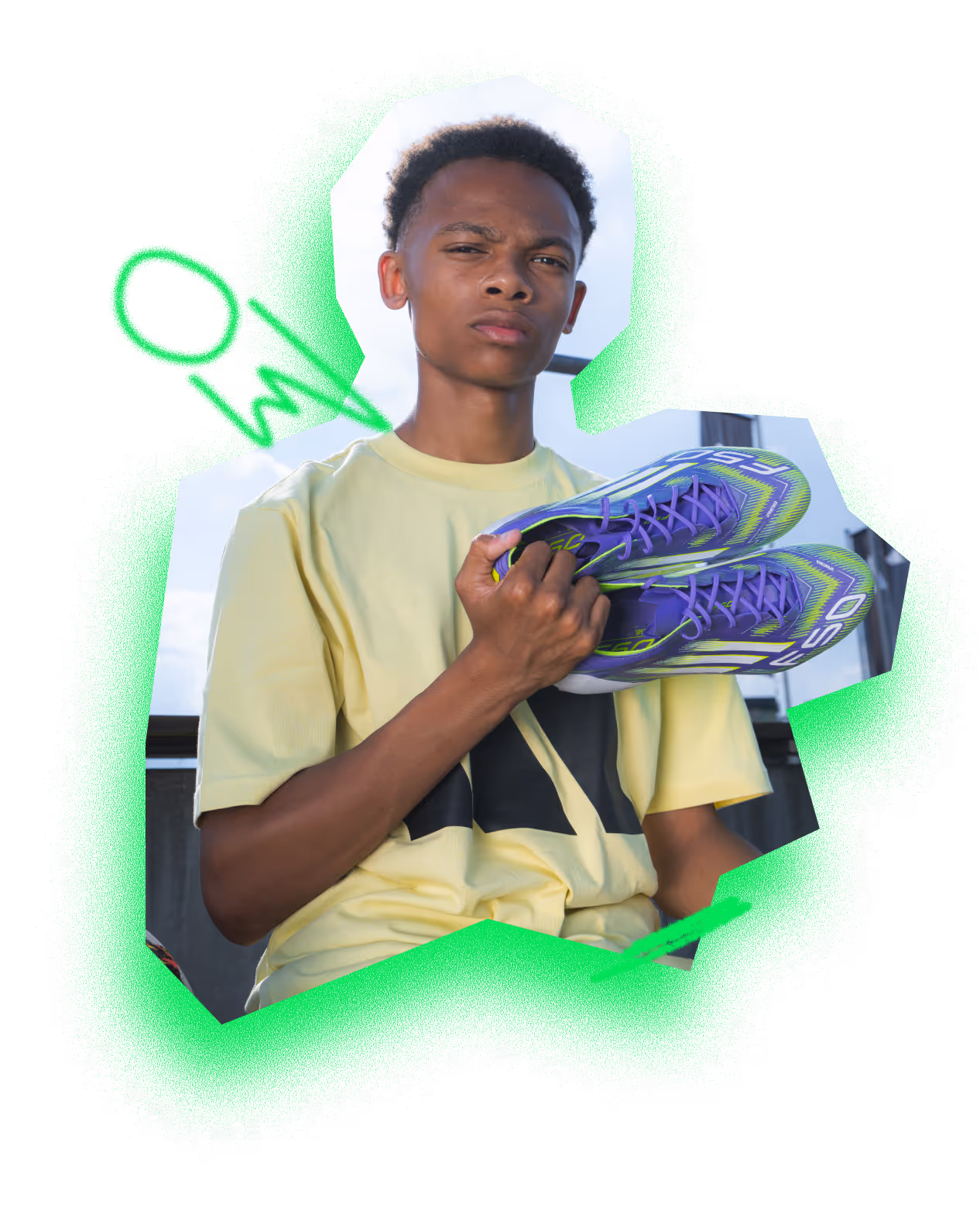 Young man in a yellow t-shirt holding a pair of purple and green athletic shoes.