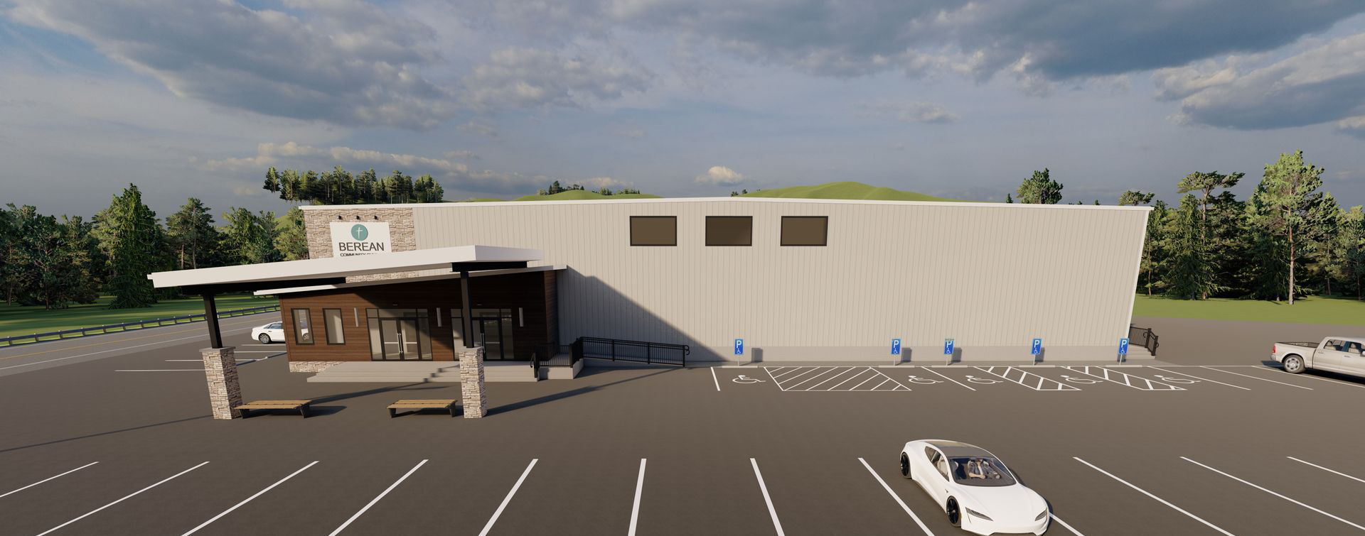 Modern one-story community building with a flat roof, large glass entrance, wooden facade, handicap accessible ramps, and dedicated accessible parking spaces in the front parking lot under a partly cloudy sky.
