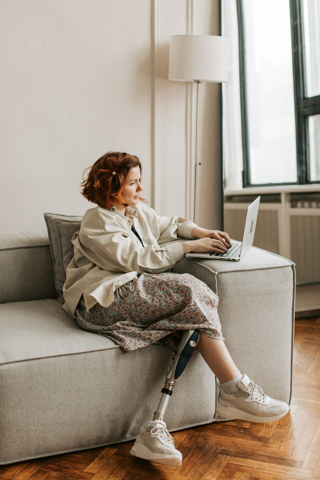 woman working on a laptop while seated on the sofa