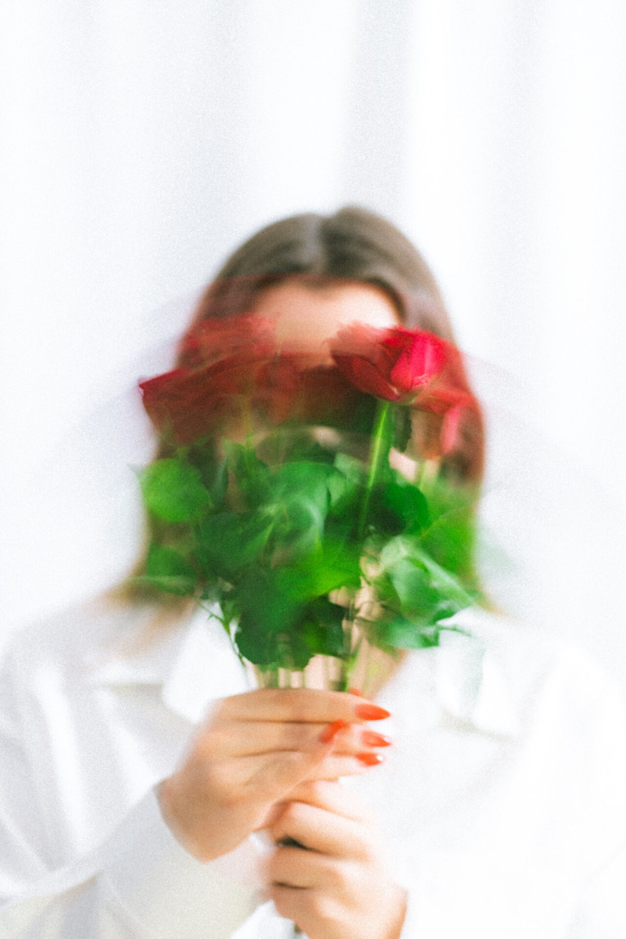 woman holding flowers infront of her face