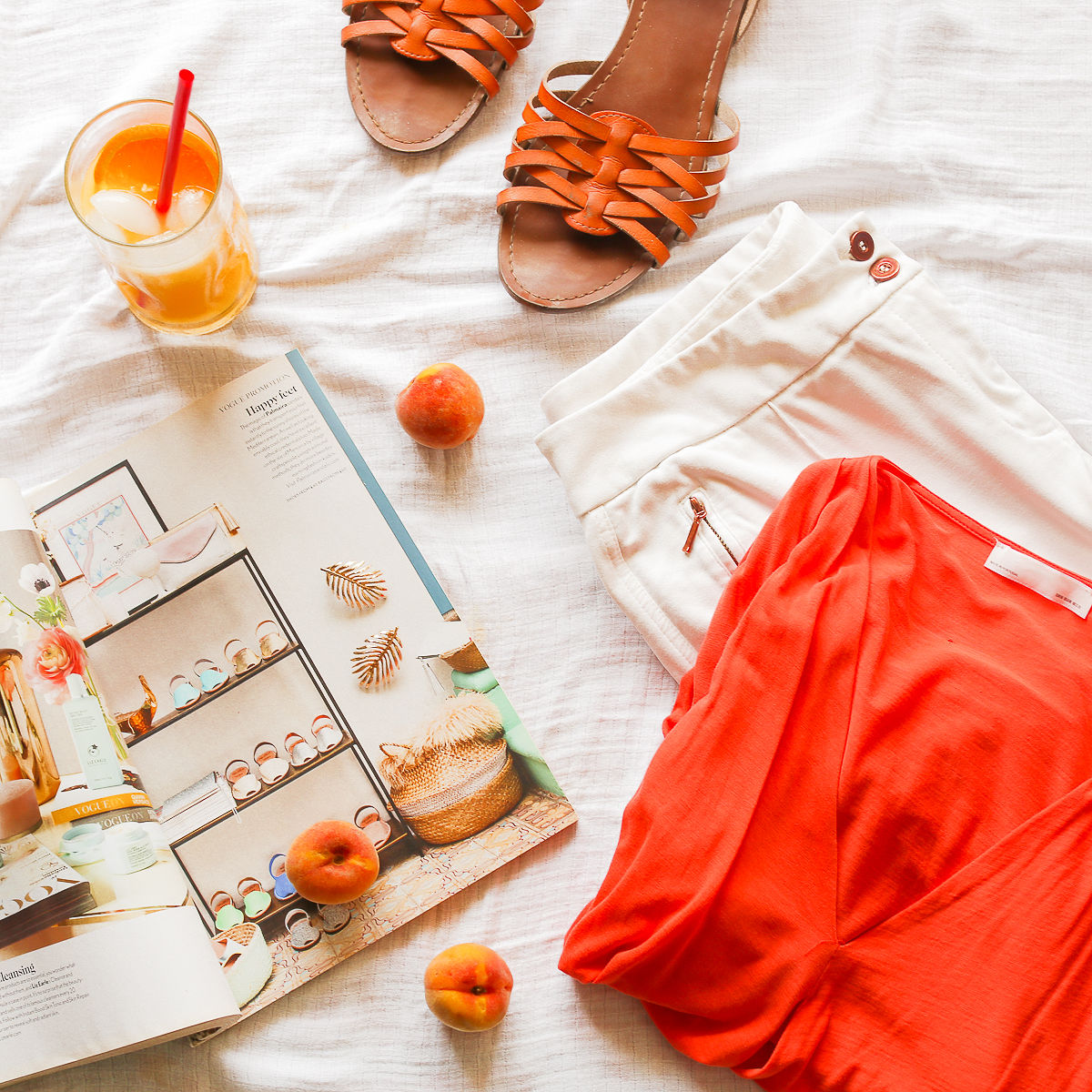 sandals, a magazine and clothes laid out on a surface