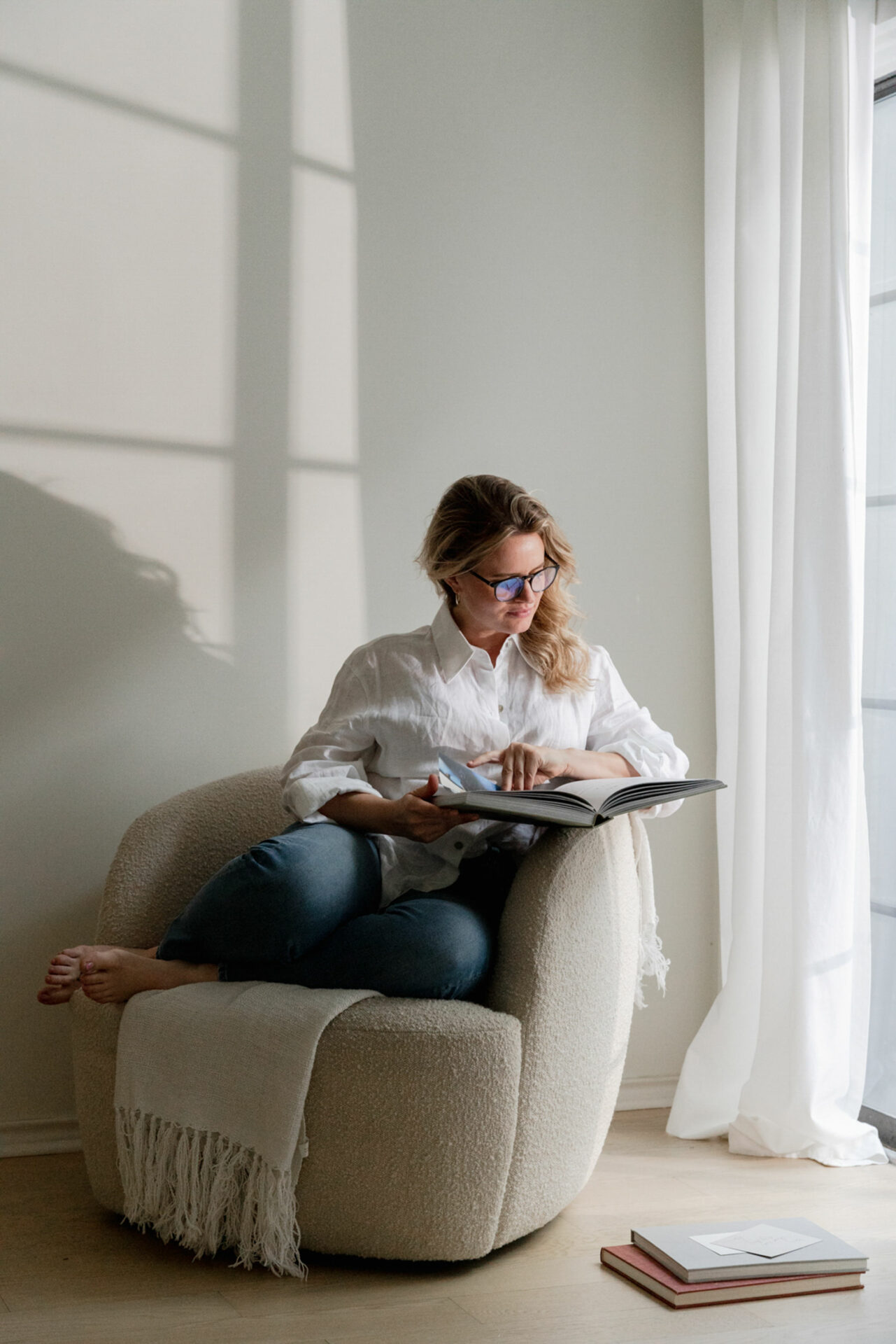 woman seated on the sofa browsing through a magazine