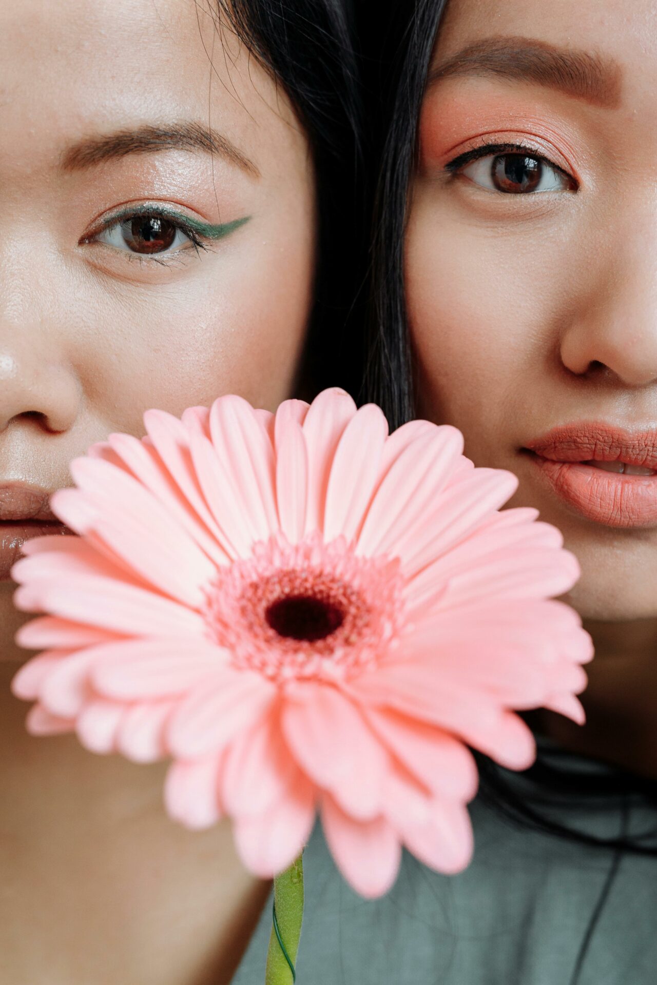 2 women with their faces touching and a flower infront of them