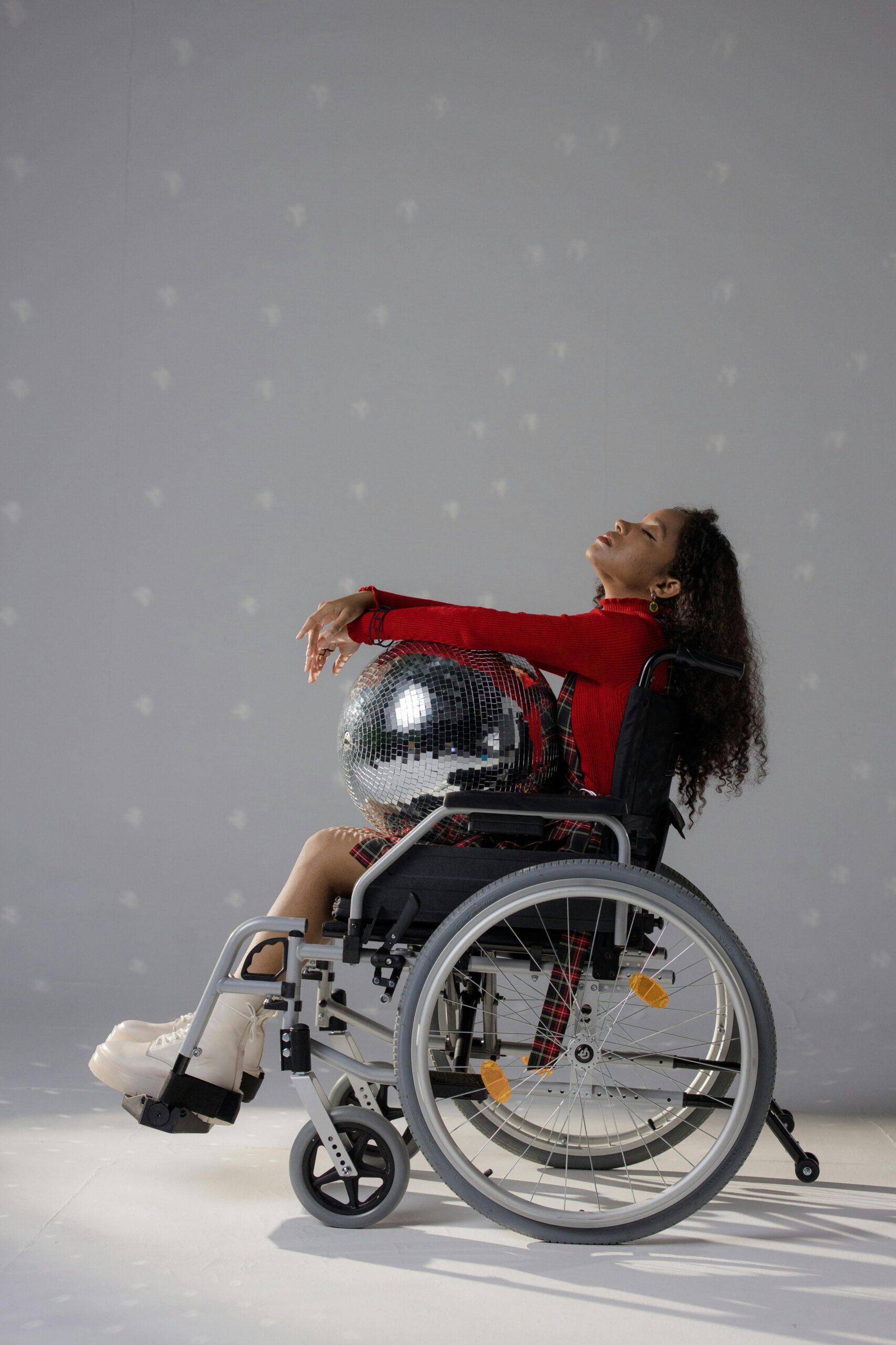 woman in a wheelchair holding a disco ball